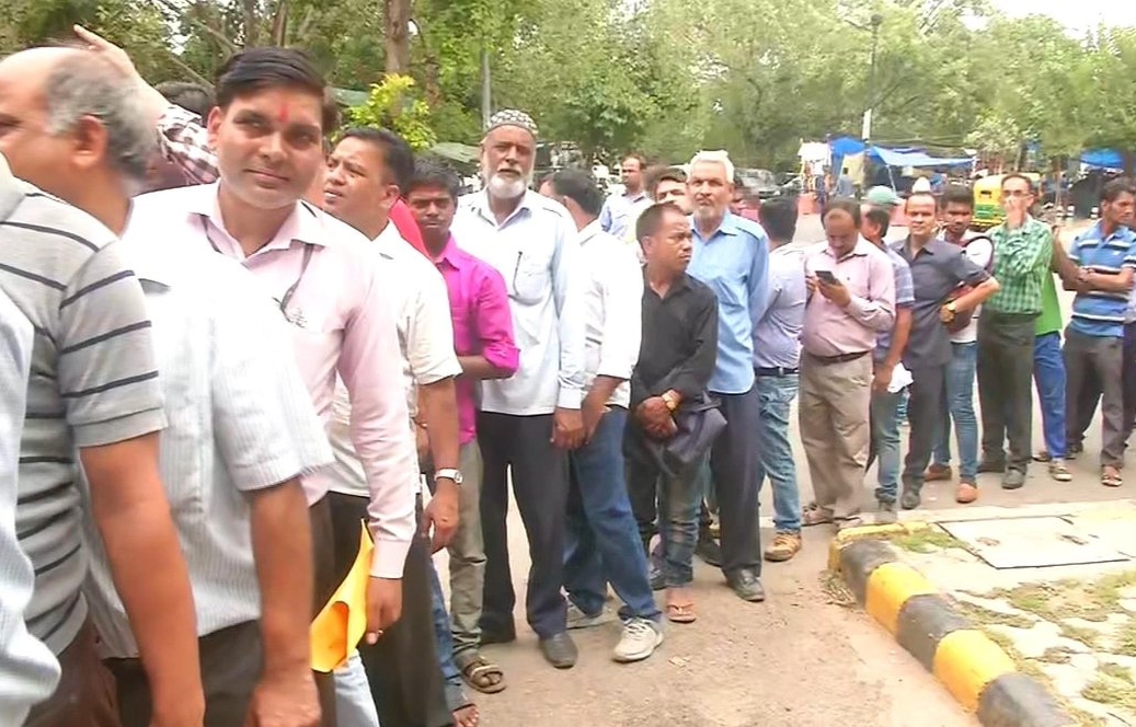 People queue up to buy onions being sold at Rs. 22 per kg