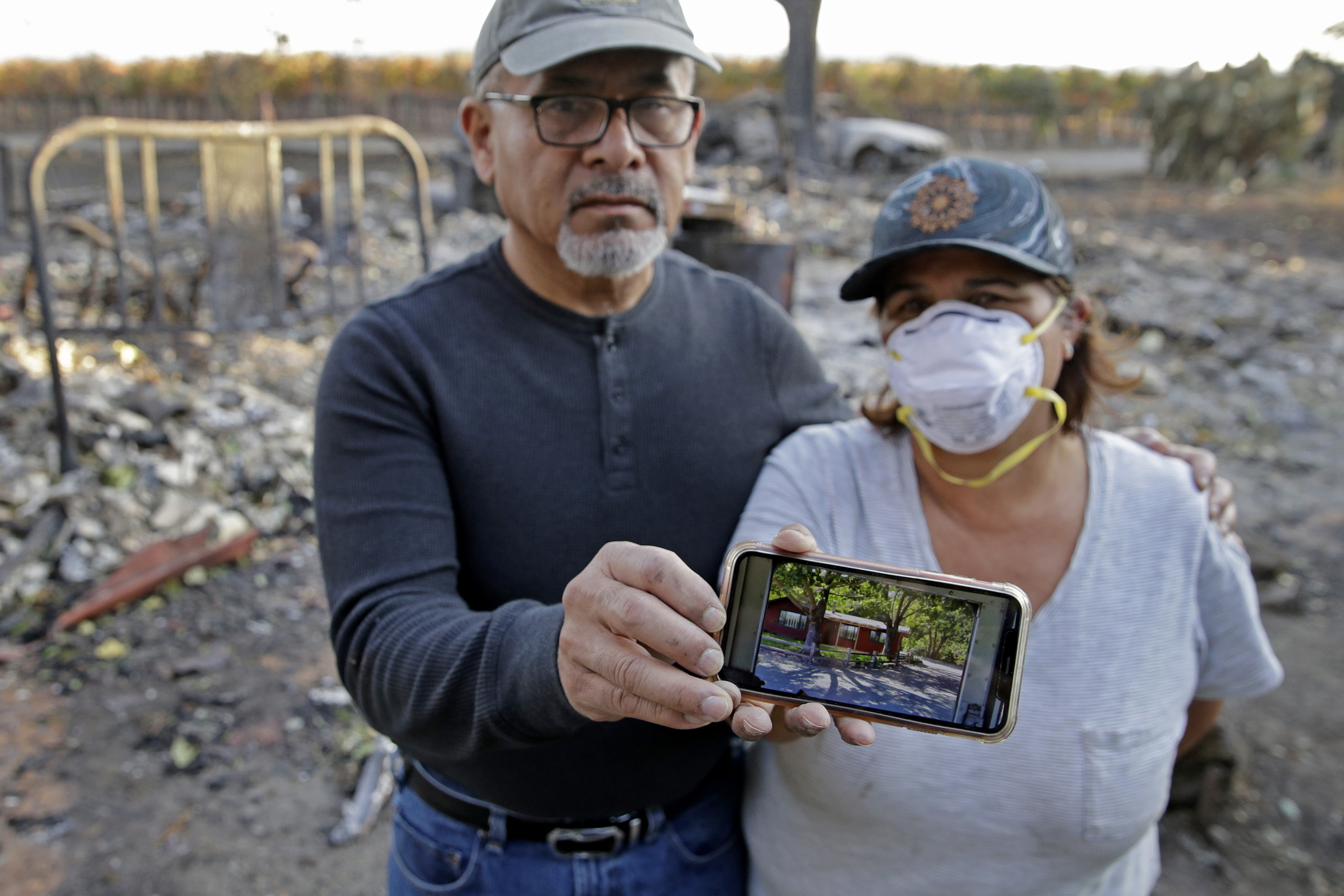 Justo and Bernadette Laos show a photo of the home they rented that was destroyed by wildfire