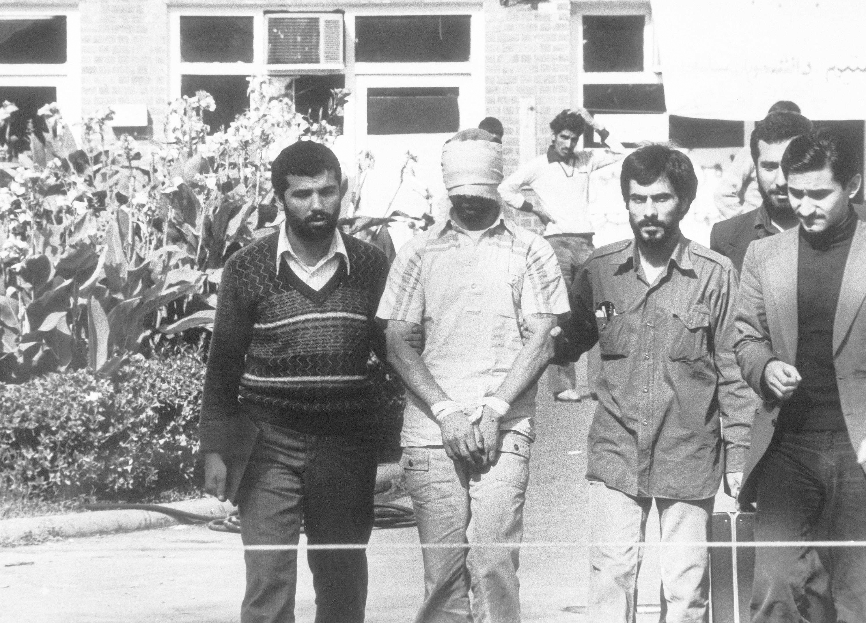 FILE - In this Nov. 8, 1979 file photo, one of the hostages held at the U.S. Embassy in Tehran, is shown to the crowd by Iranian students.