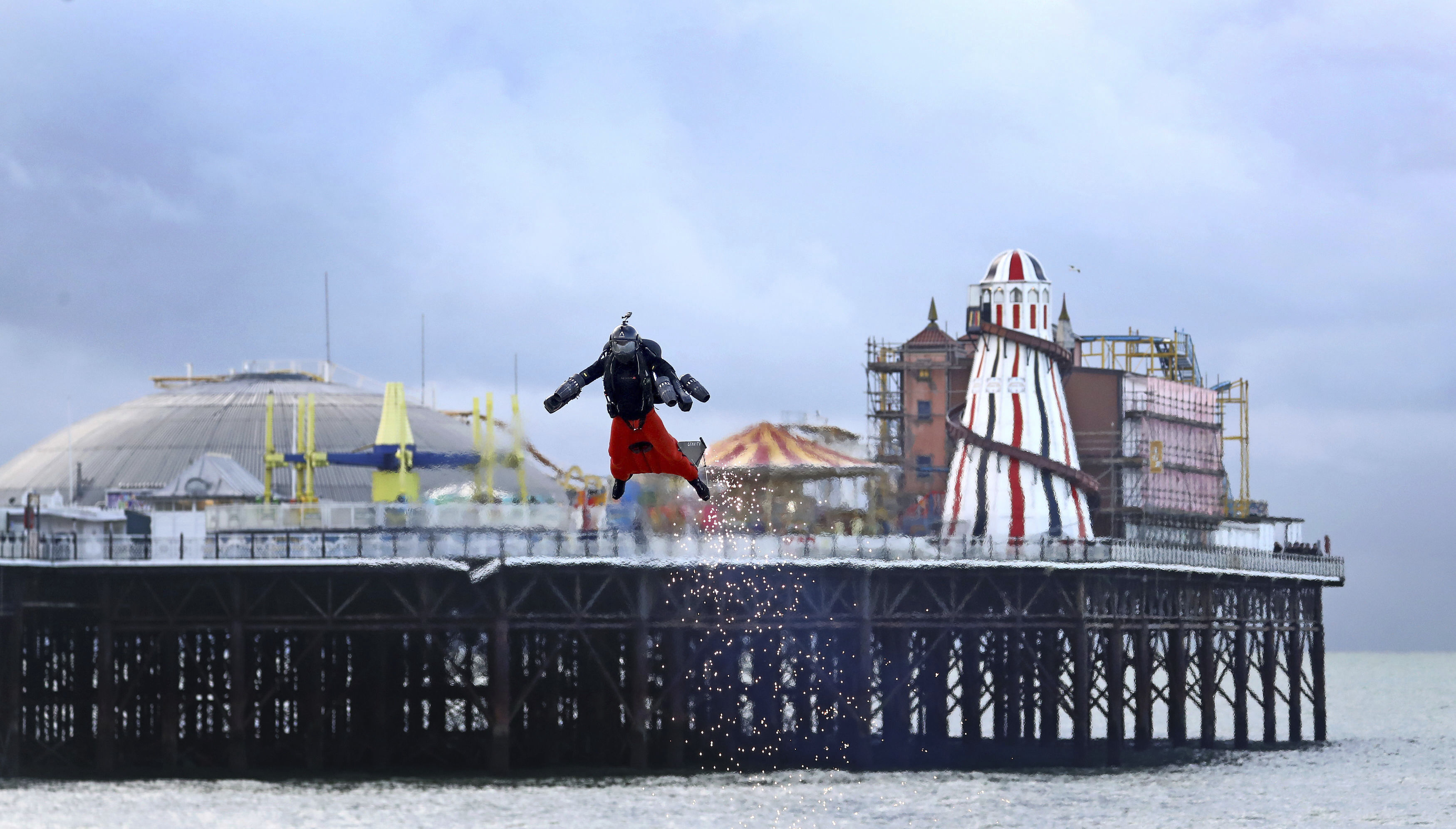 Richard Browning prepares for an attempt to break his own World Record for the fastest speed in a body-controlled jet engine powered suit, backdropped by Brighton Pier in Brighton, England, on Thursday.