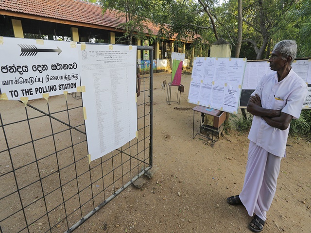 A Sri Lankan man stands outside a polling station after casting his vote in Weerawila