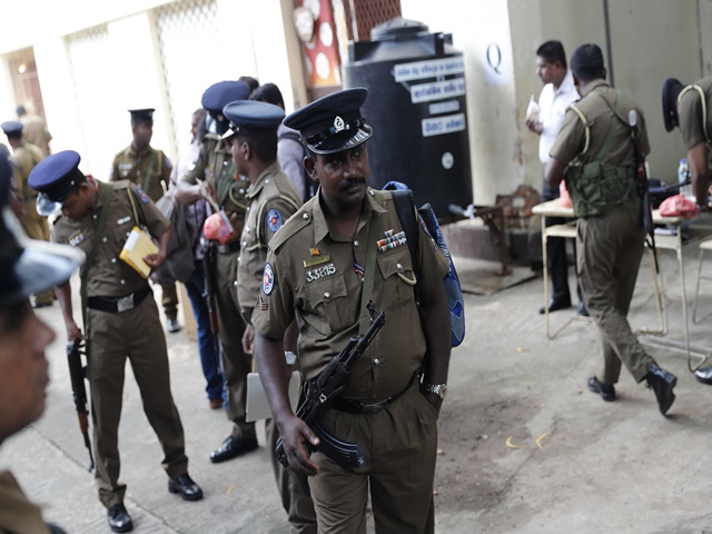 Sri Lankan police officers and polling workers wait to set off for their respective polling stations