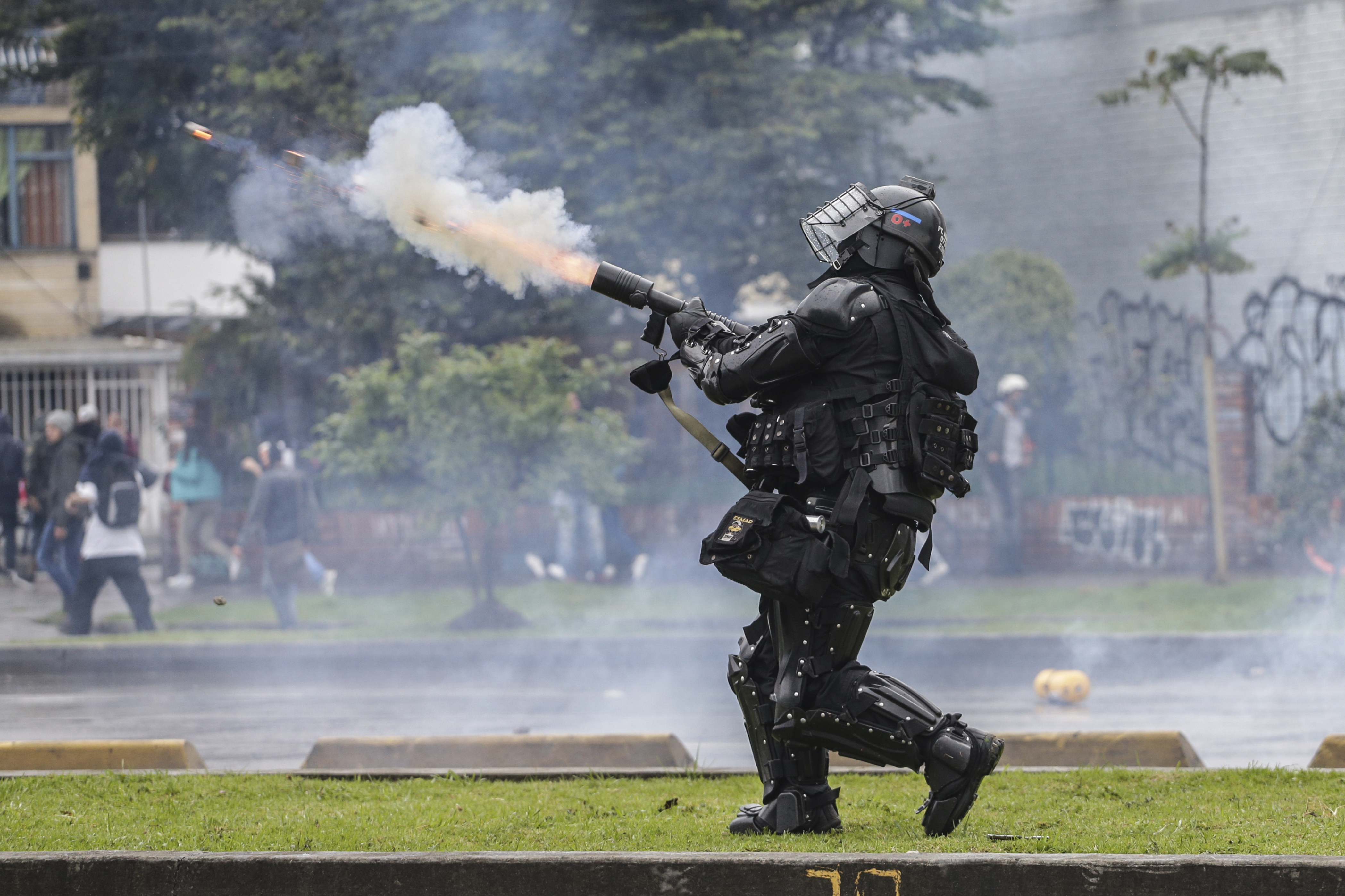 A police officer fires tear gas at anti-government protesters in Bogota, Colombia, on Thursday.