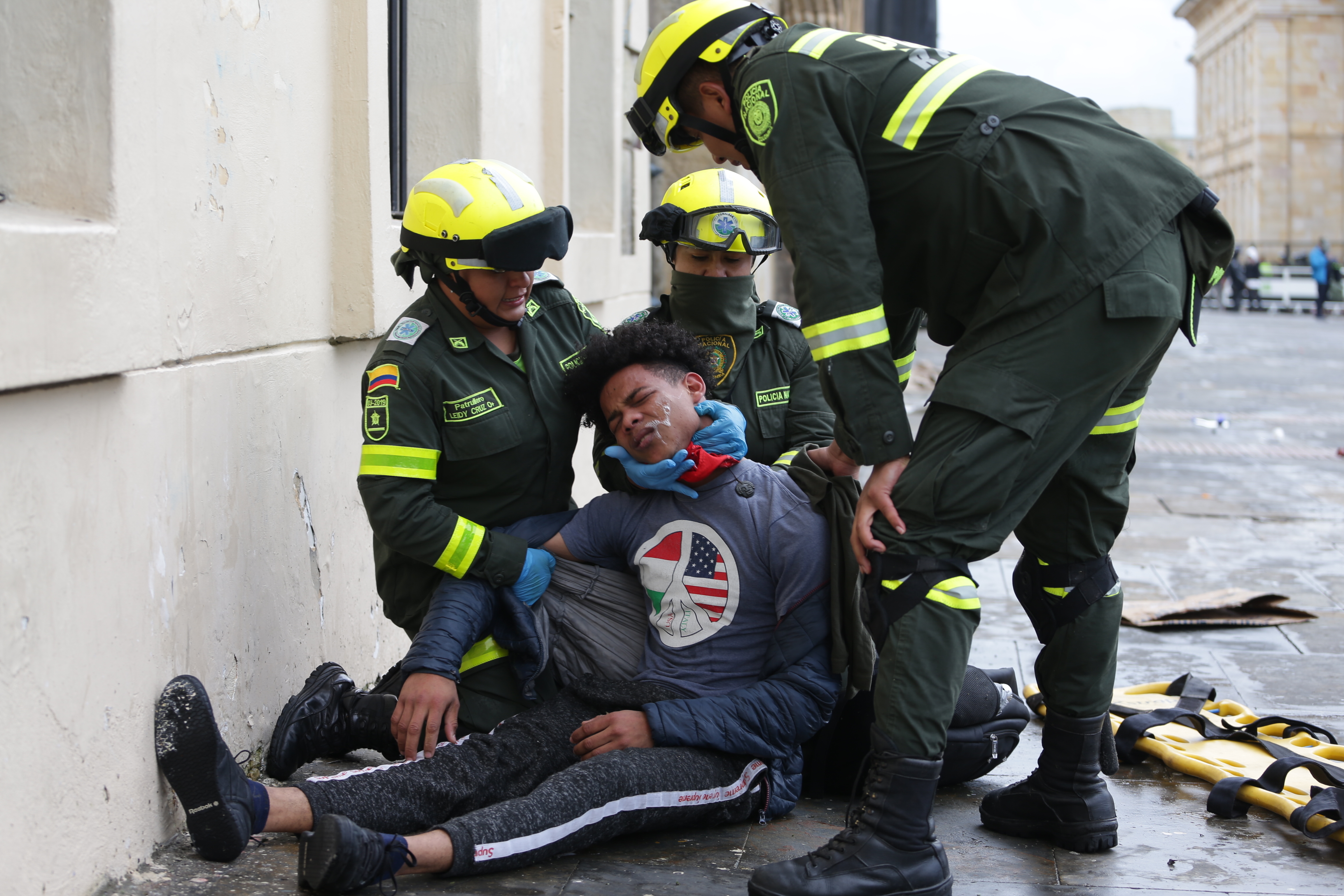 Police attend an anti-government protester affected by tear gas during clashes in downtown Bogota, on Friday.