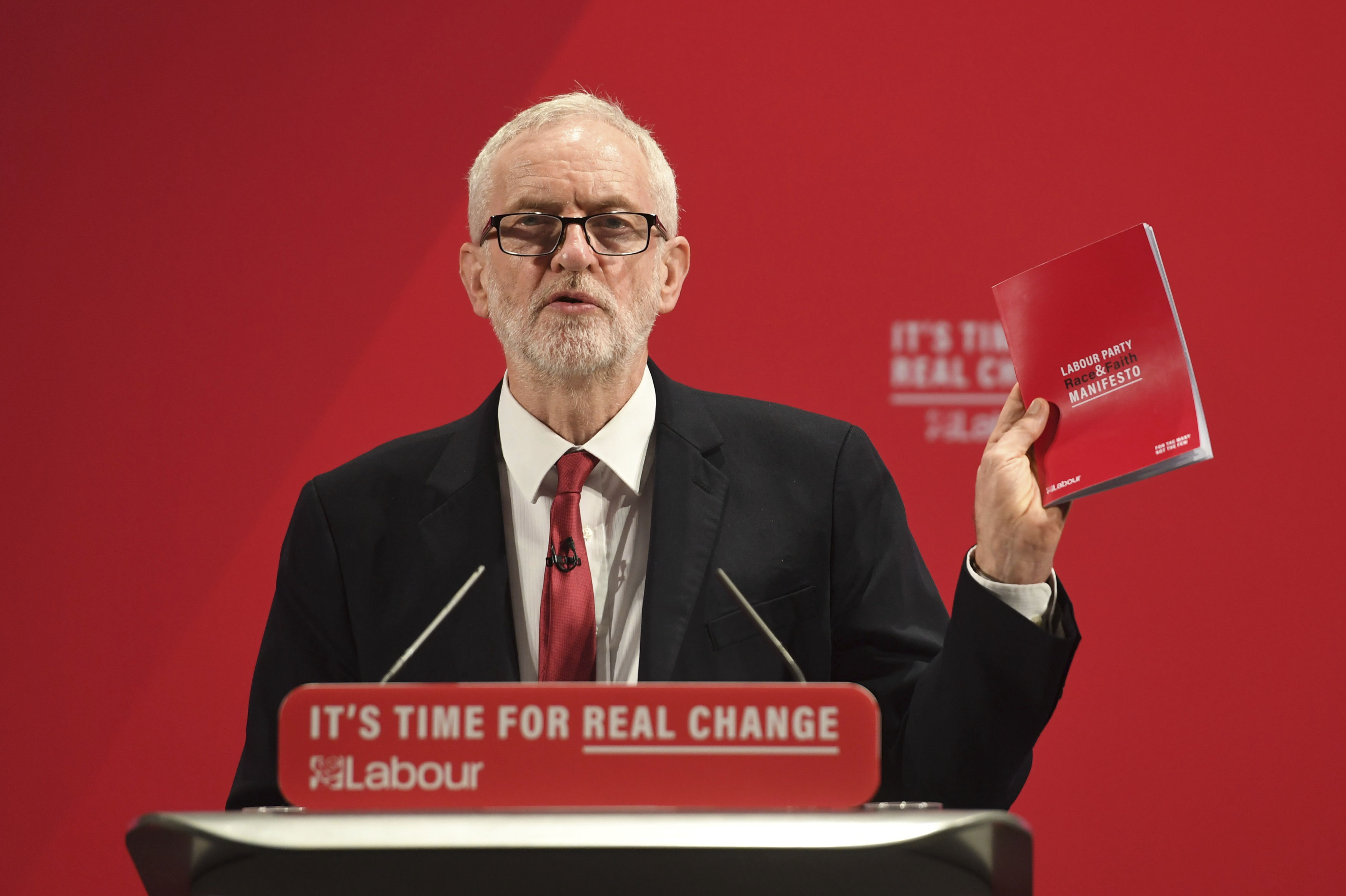 Britain's main opposition Labour Party leader Jeremy Corbyn holds a copy of the party race and faith manifesto in London, on Tuesday.