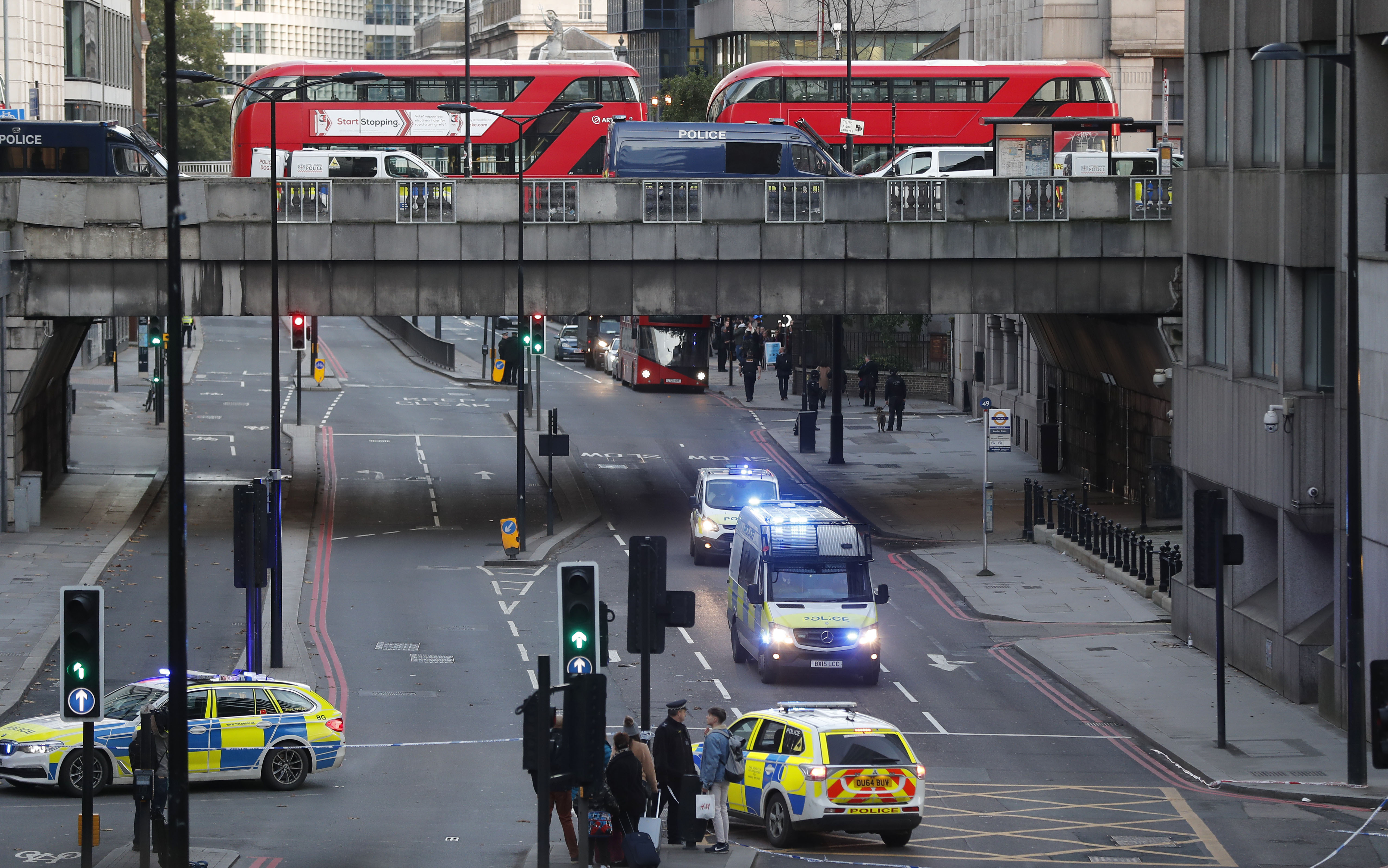 Police vehicles and buses on top and underneath London Bridge in London, on Friday.