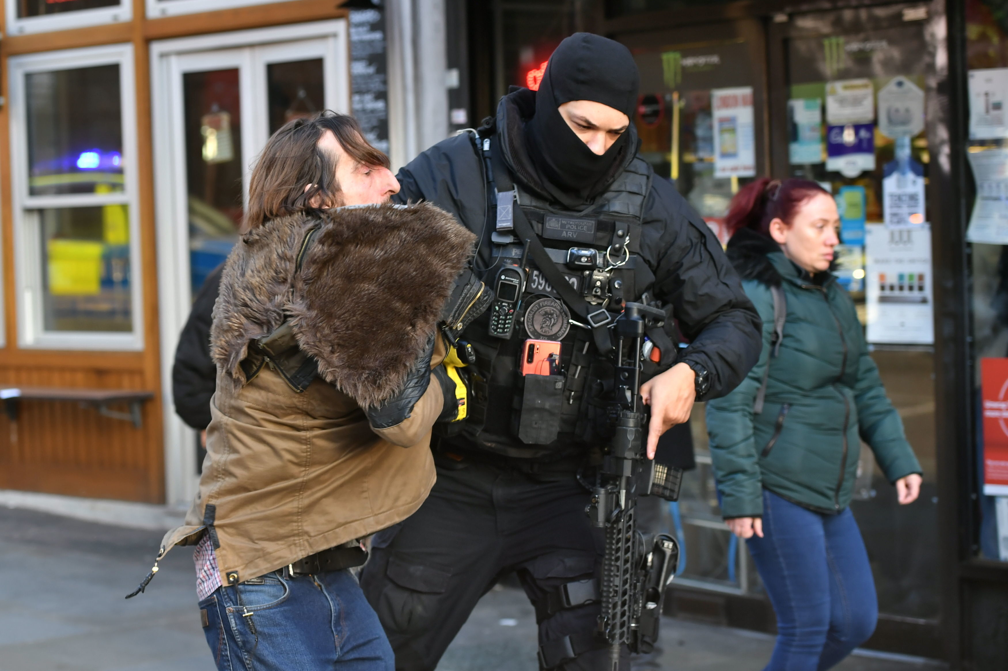 A police officer moves an uninvolved person away from a cordon after an incident on London Bridge in central London following a police incident, on Friday.