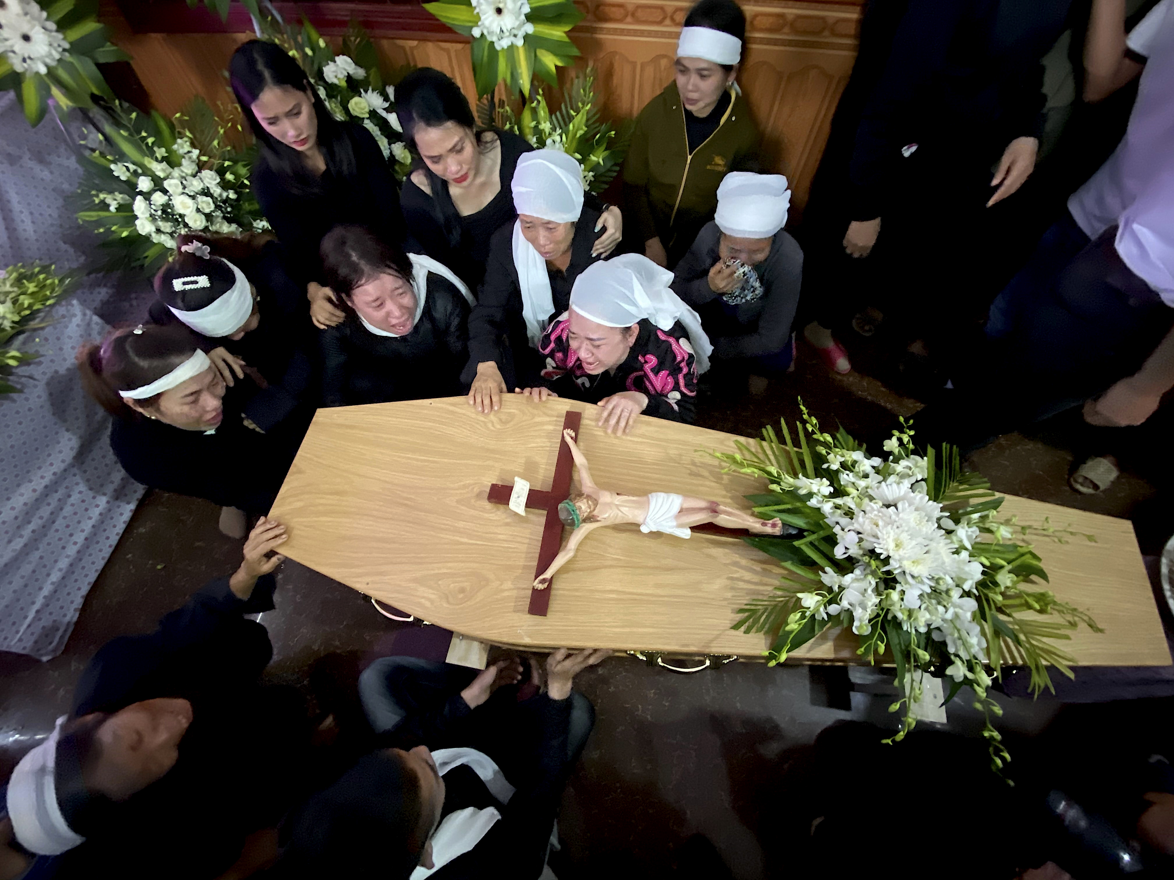 Relatives of Bui Thi Nhung weep as they gather around Nhung's casket at the family home on Saturday in the village of Do Thanh, Vietnam.