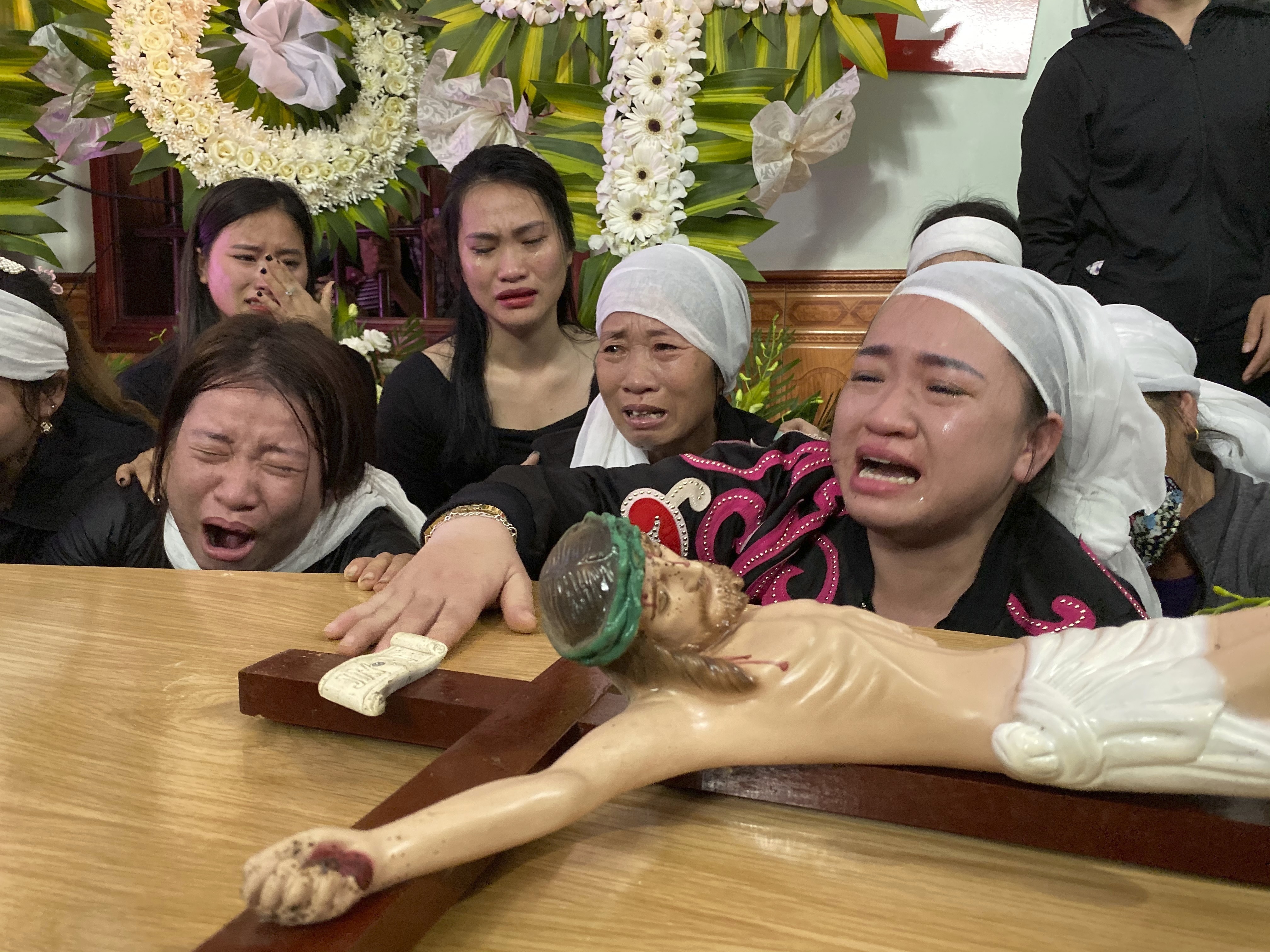 Relatives of Bui Thi Nhung weep as they gather around Nhung's casket at the family home on Saturday in the village of Do Thanh, Vietnam.