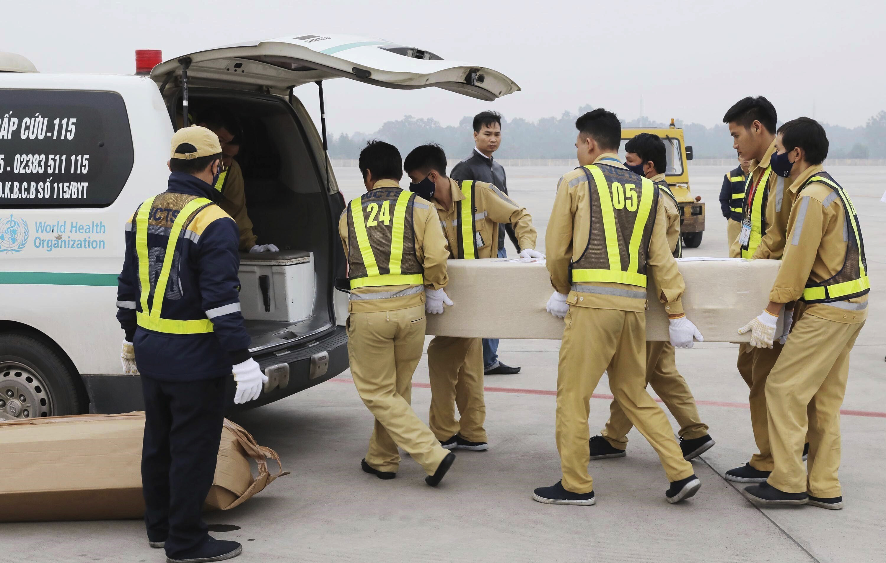 Airport workers load a coffin into the back of an ambulance at the Noi Bai airport in Hanoi, Vietnam, on Saturday.