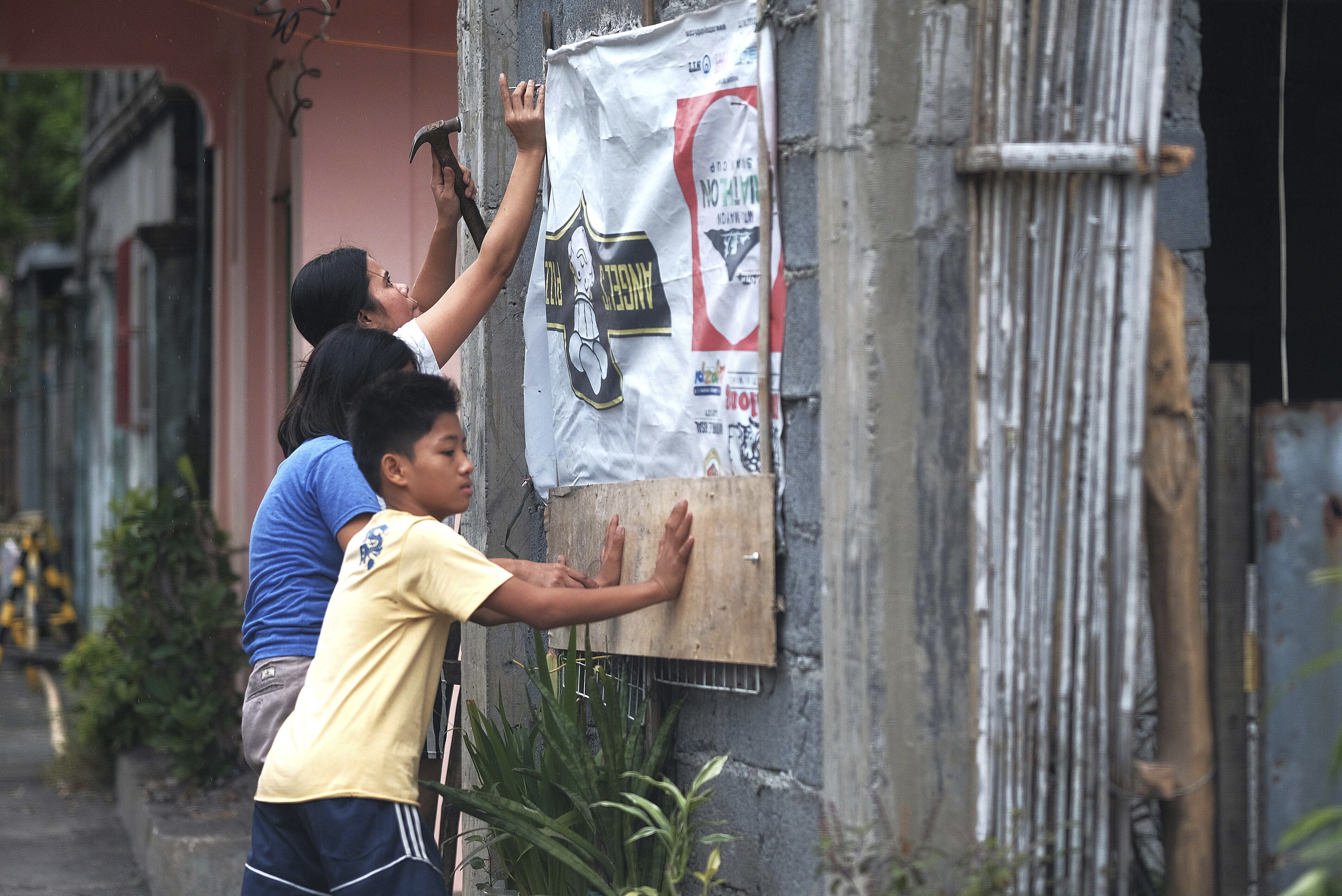 Residents reinforce their house as they prepare for a coming typhoon in outheast of Manila, Philippines, on Monday.