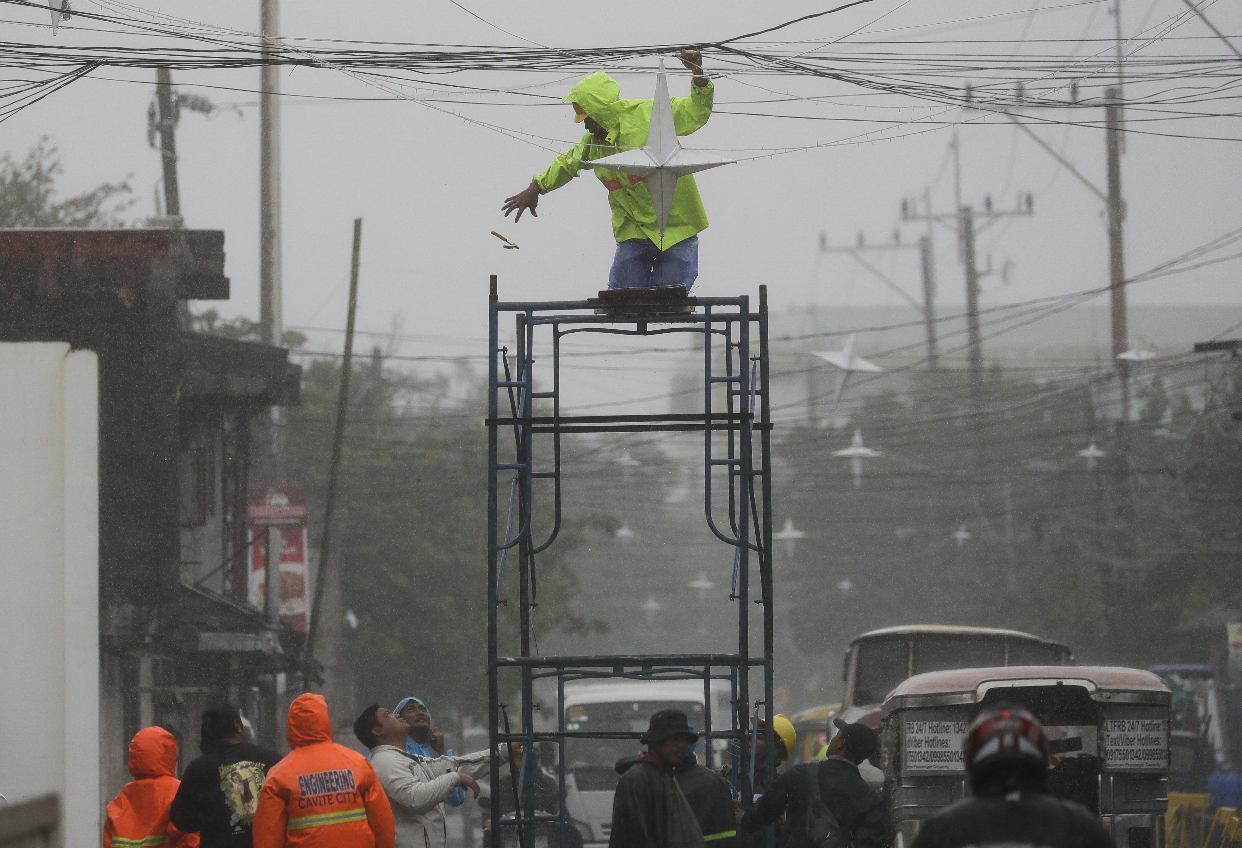 A man prepares to take down Christmas lanterns as they prepare for approaching Typhoon Kammuri on Tuesday in south of Manila.