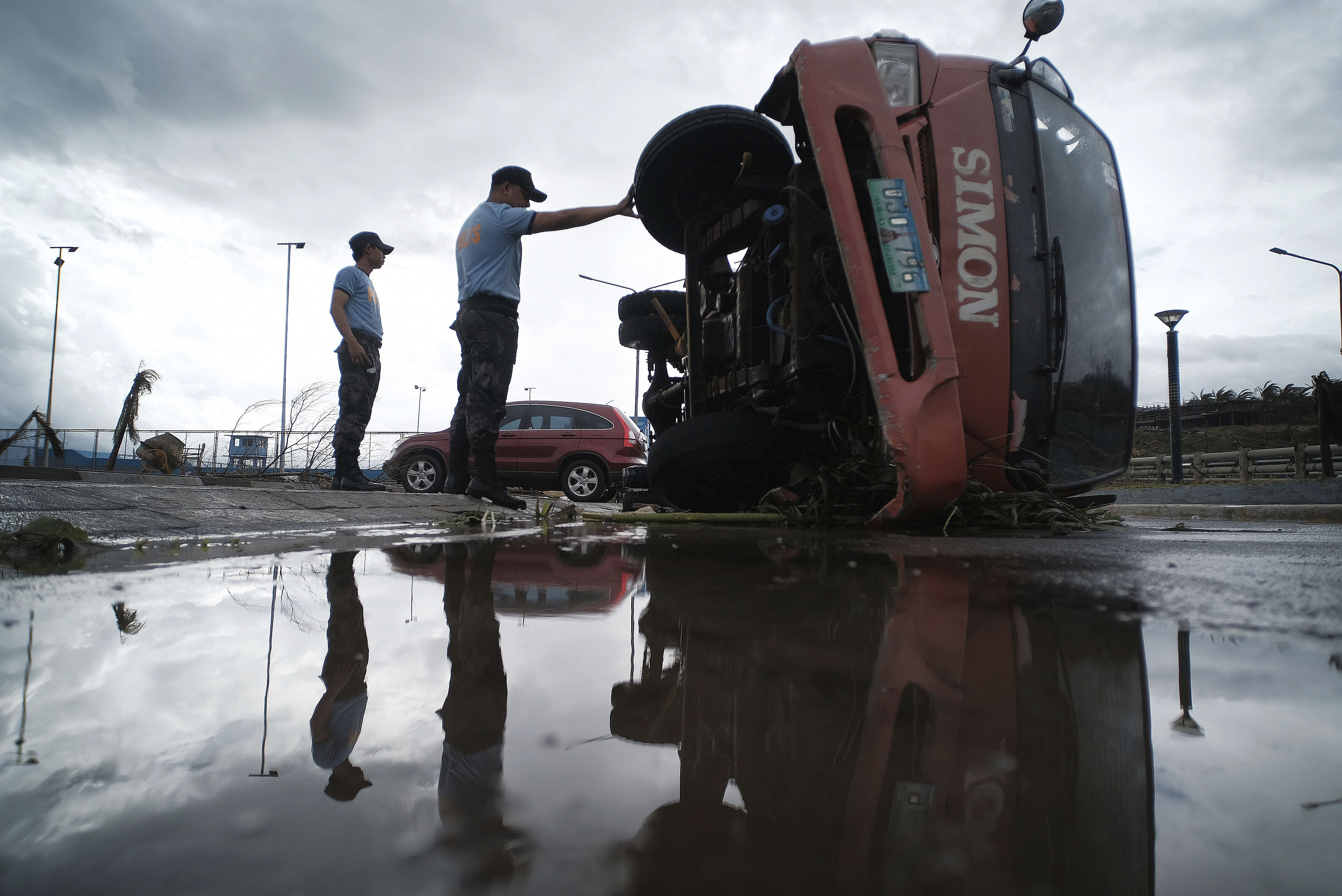 Police inspect a truck that was damaged as Typhoon Kammuri slammed southeast of Manila, Philippines, on Tuesday.