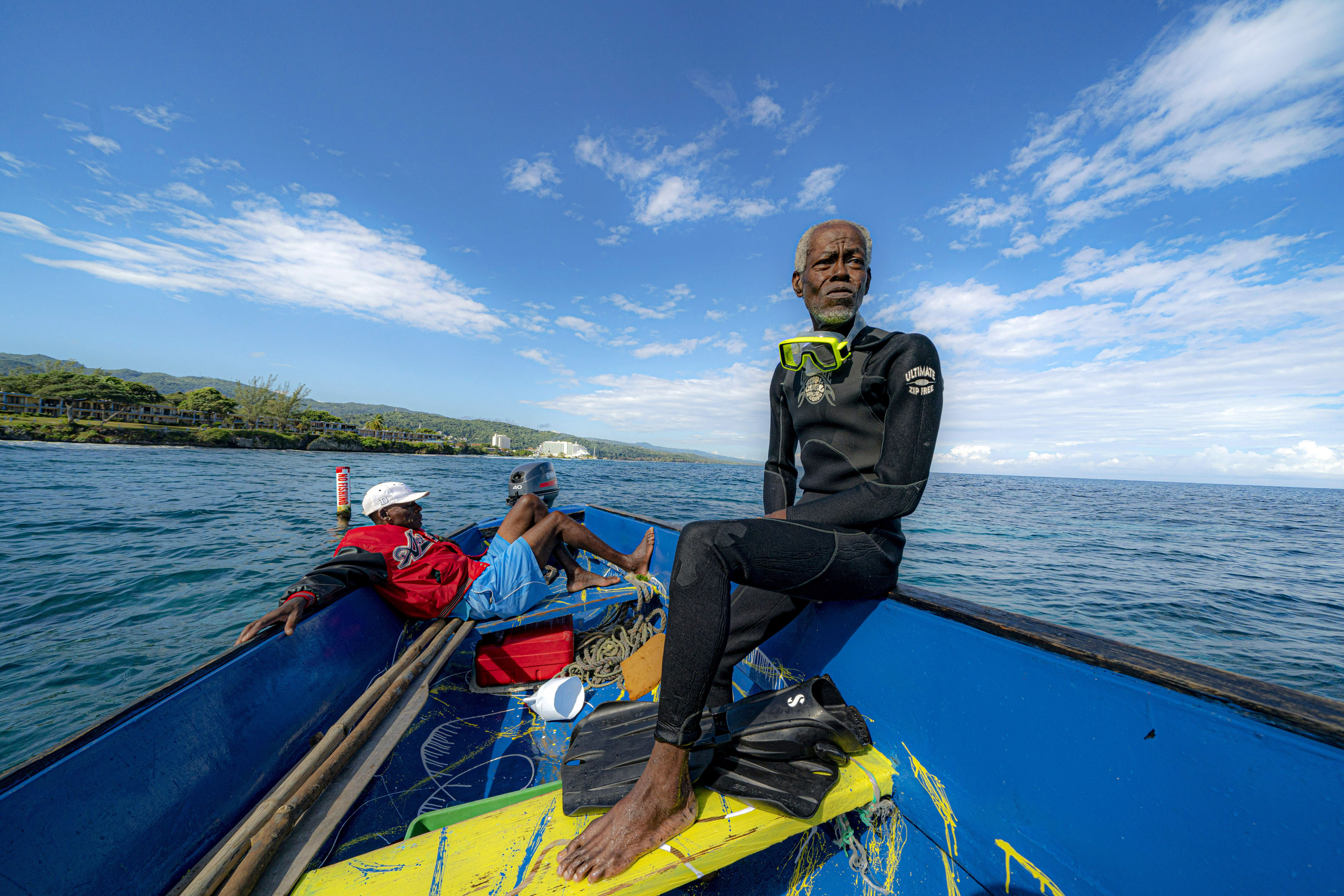 Everton Simpson sits, right, on a boat in-between dives on the White River Fish Sanctuary with Mark Lobban on Monday in Ocho Rios, Jamaica.