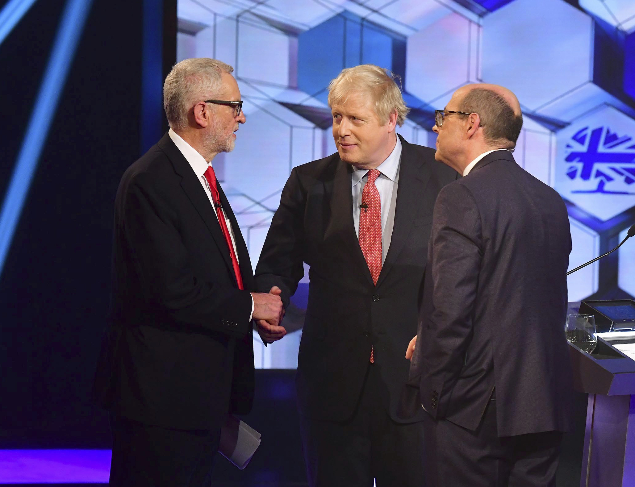 Opposition Labour Party leader Jeremy Corbyn, left, shakes hands with Britain's Prime Minister Boris Johnson, centre, with debate moderator TV presenter Nick Robinson, right, during a head to head live Election Debate at the BBC TV studios in Maidstone, England, on Friday.