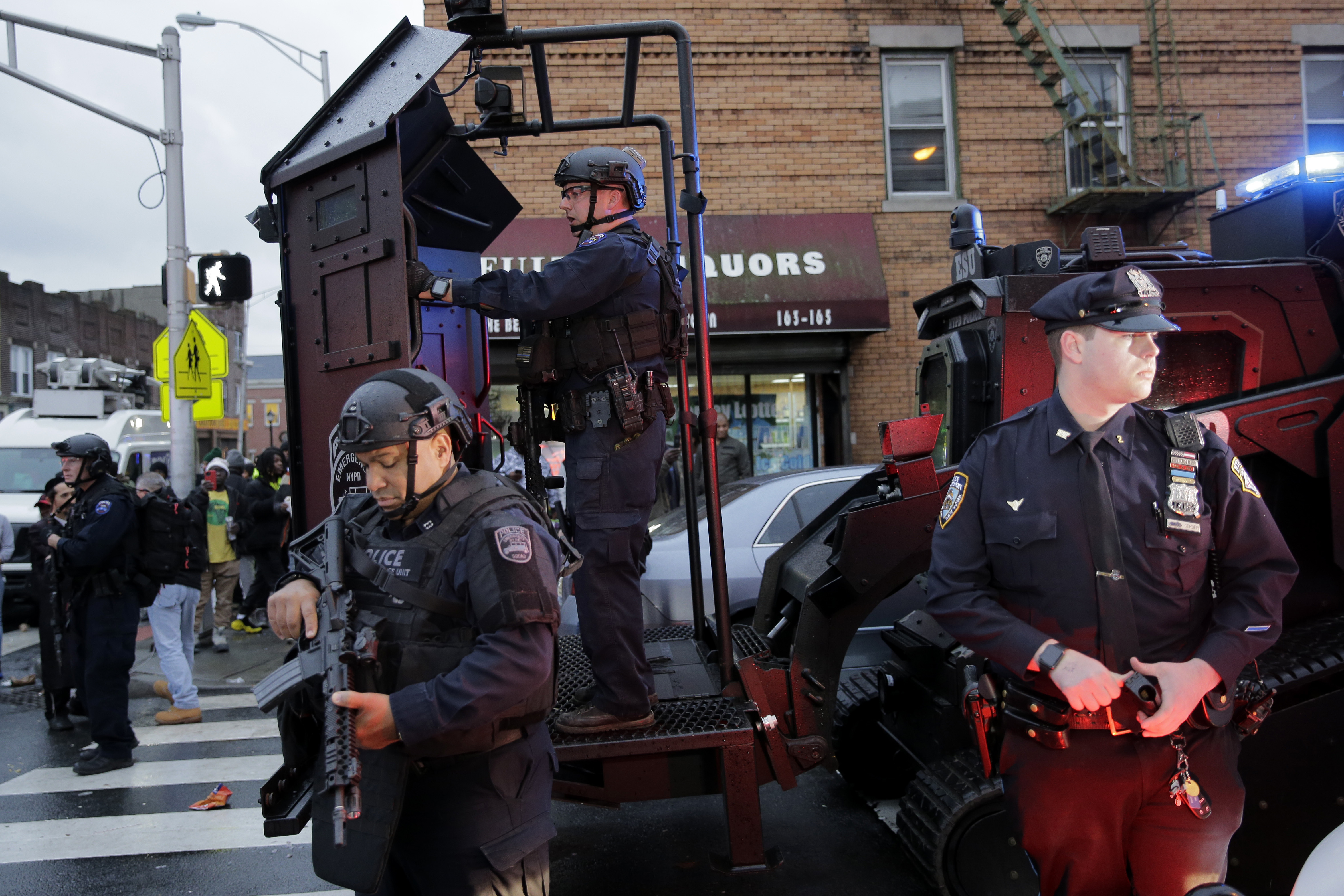 Emergency responders move heavy equipment near the scene of a shooting in Jersey City, N.J., on Tuesday.