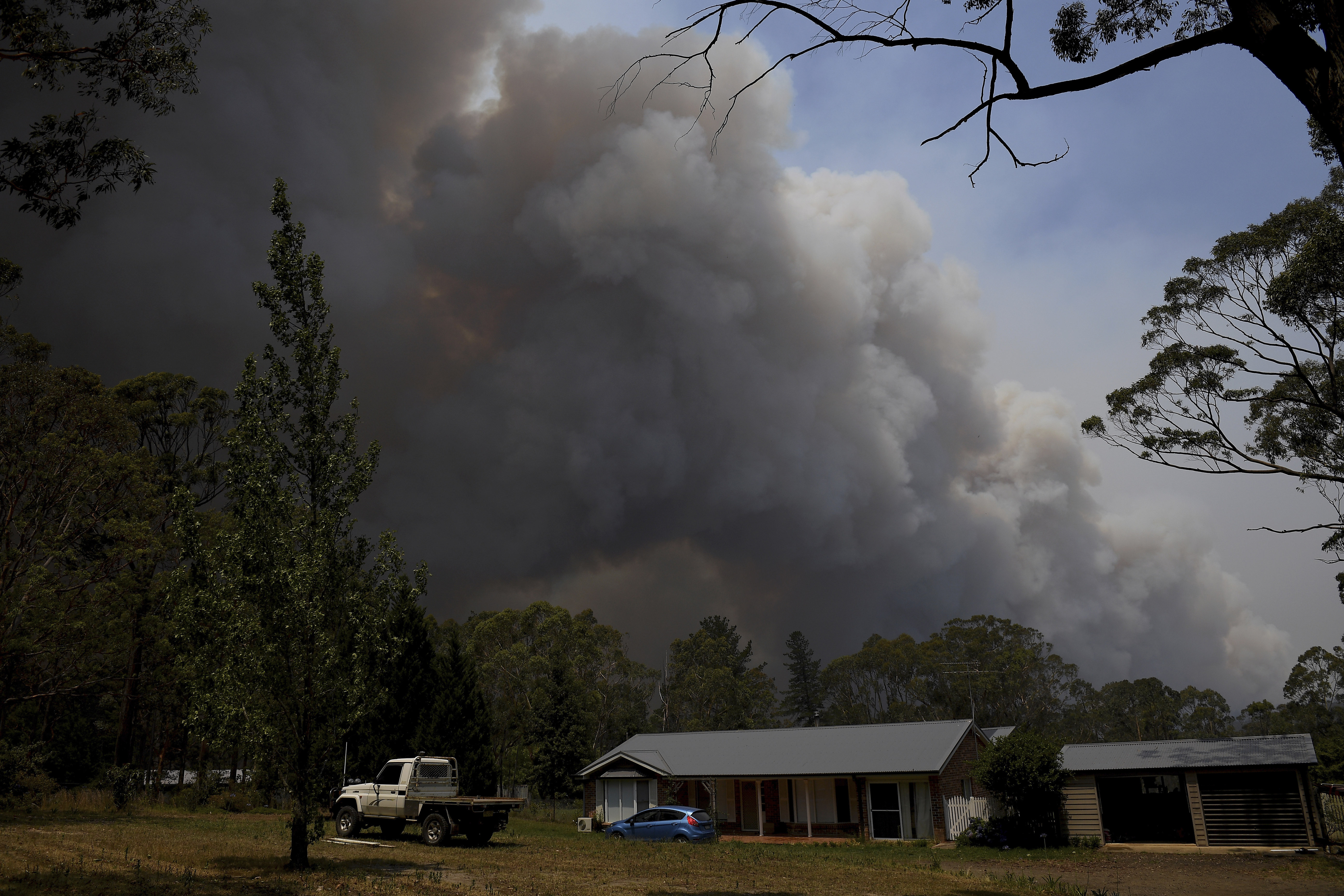 A home stands as smoke from the Grose Valley fire rises in the distance in Bilpin, west of Sydney, on Saturday.