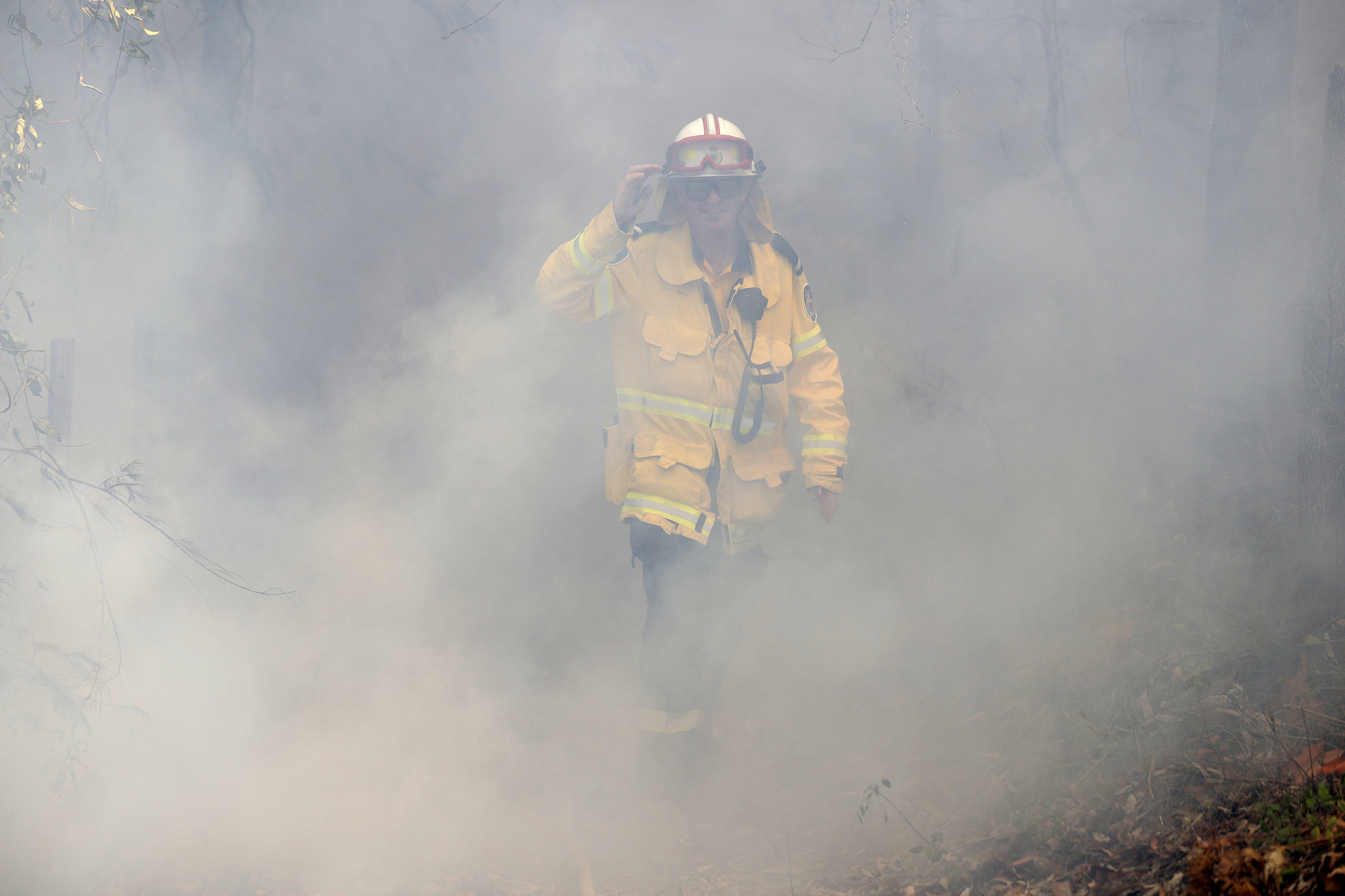 A firefighter walks through thick smoke as he monitors a backburn near Mangrove Mountain, north of Sydney, Australia, on Sunday.