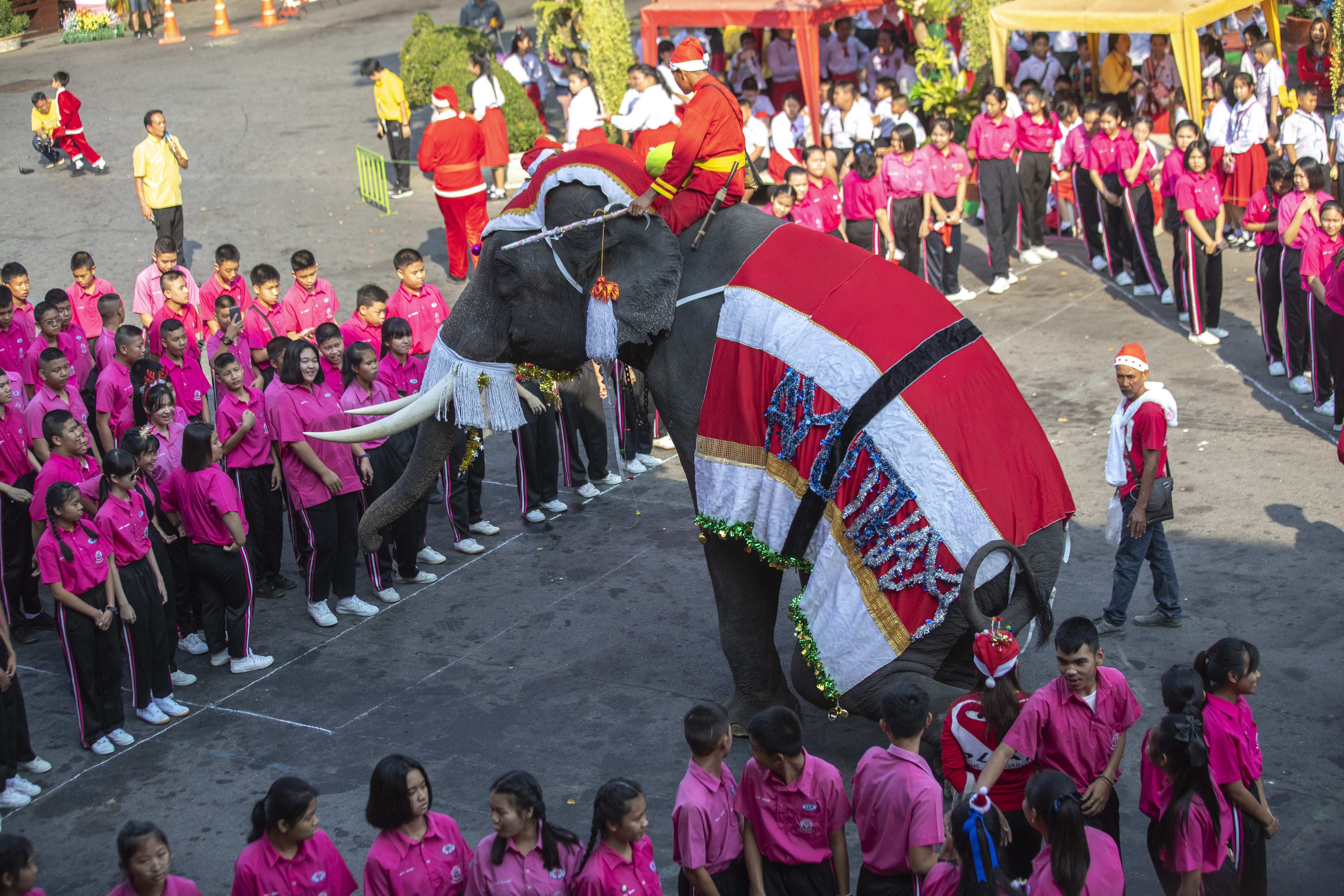 An elephant dressed in a Santa Claus costume performs for children at the Jirasartwitthaya school during Christmas celebrations in Ayutthaya, on Monday.