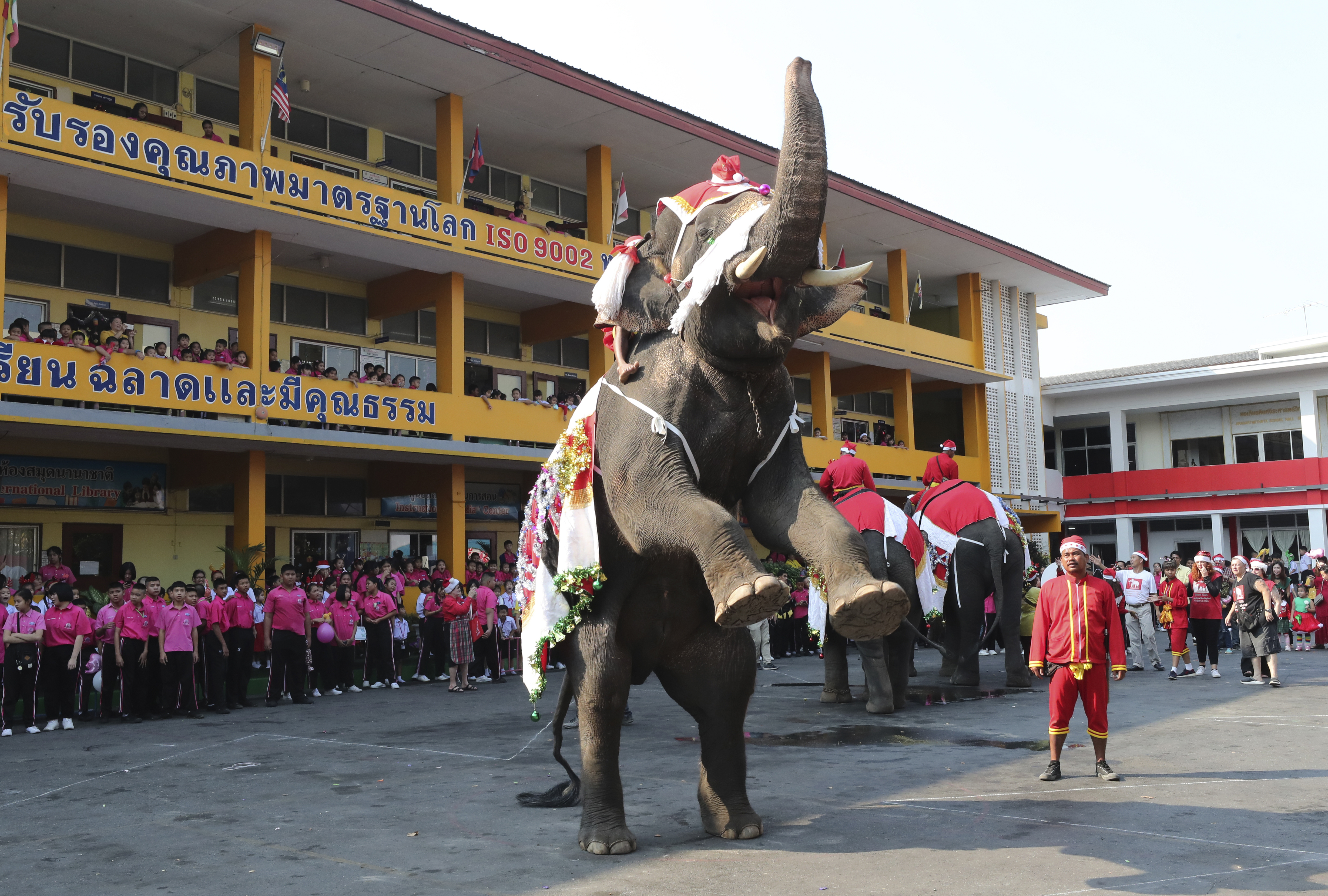 An elephant dressed in a Santa Claus costume performs for children at the Jirasartwitthaya school during Christmas celebrations in Ayutthaya, on Monday.