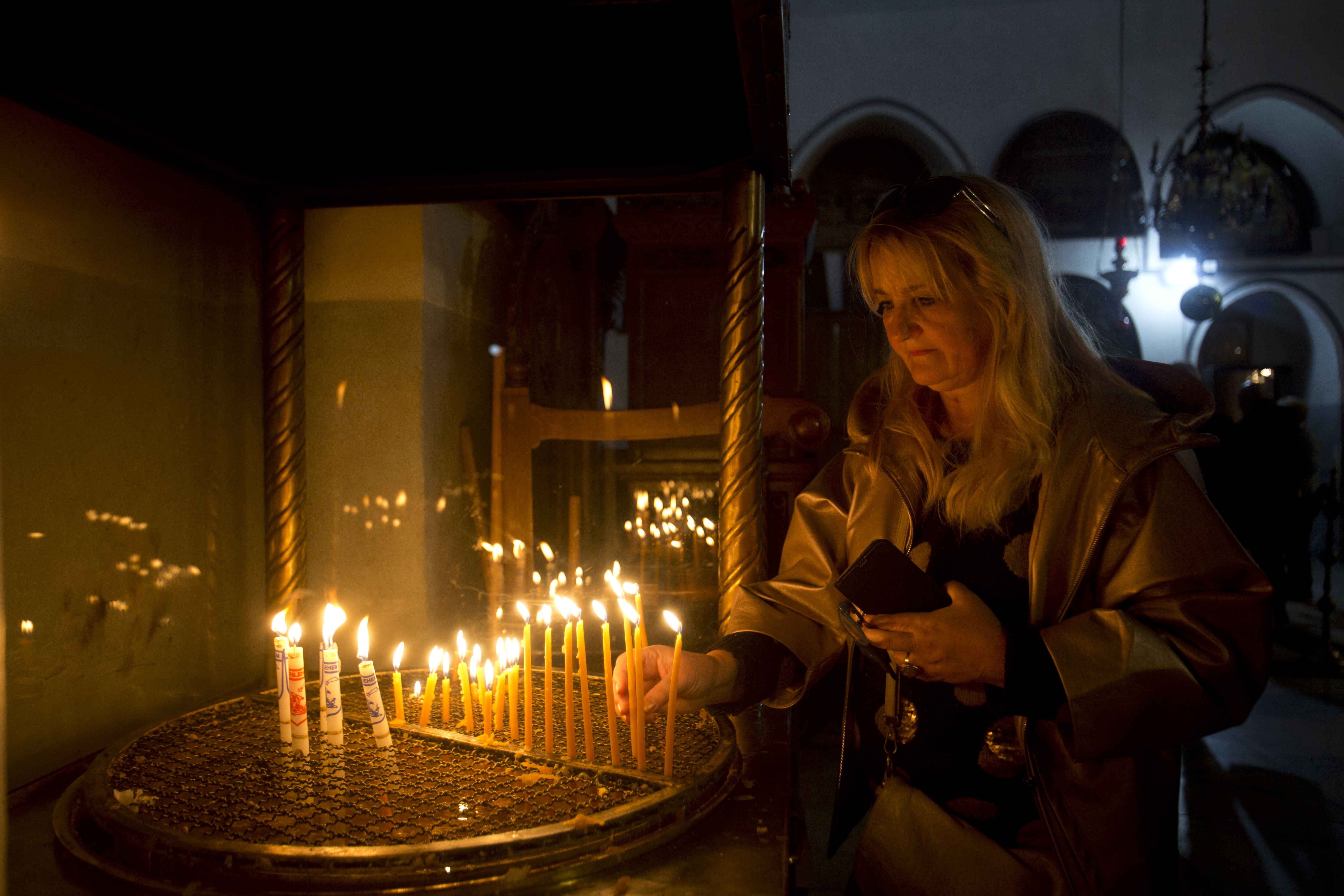 A visitor lights a candle at the Church of the Nativity built on top of the site where Christians believe Jesus Christ was born on Christmas Eve, in the West Bank City of Bethlehem.