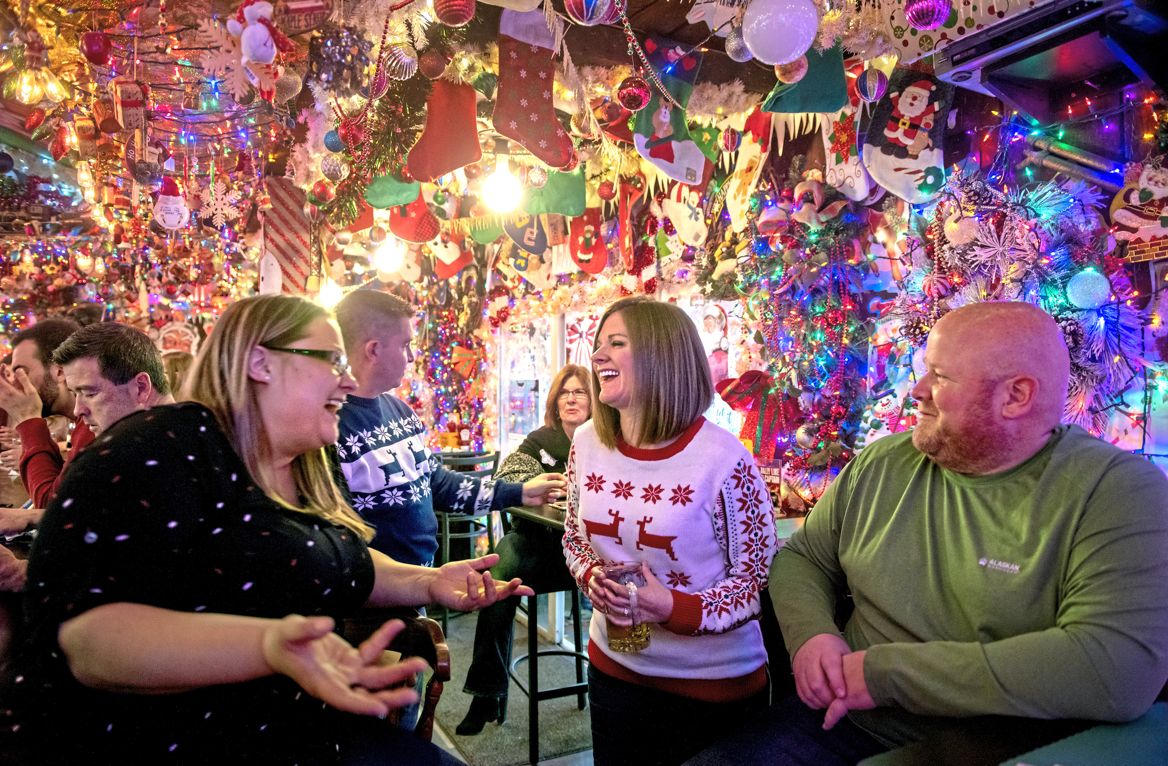 Friends follow a holiday tradition by gathering under approximately 10,000 lights decorating Bob's Garage in O'Hara Township, Pa.