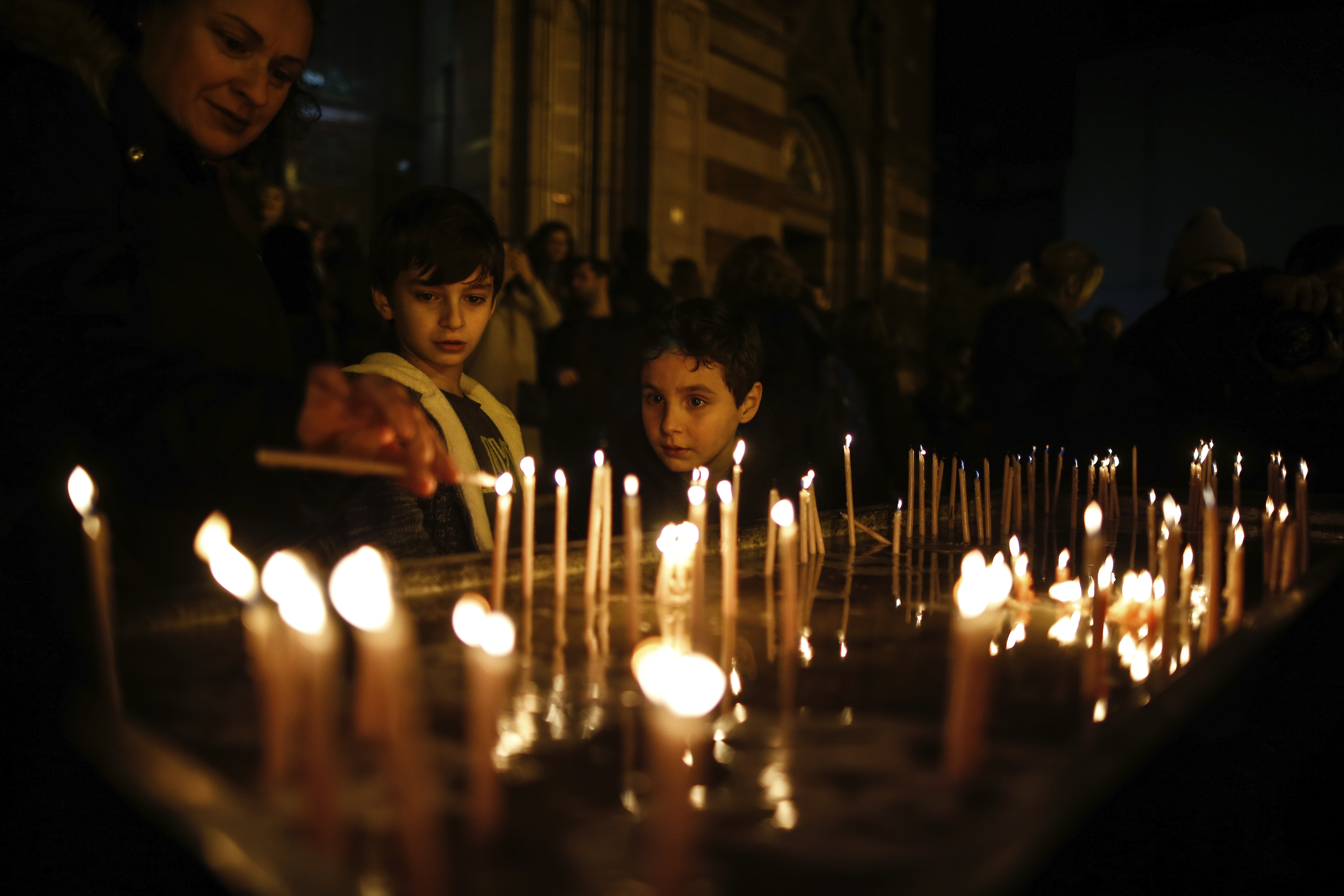 People light candles during a Catholic Christmas Eve mass in St. Antoine Church, the largest church of the Roman Catholic Church, in Istanbul.