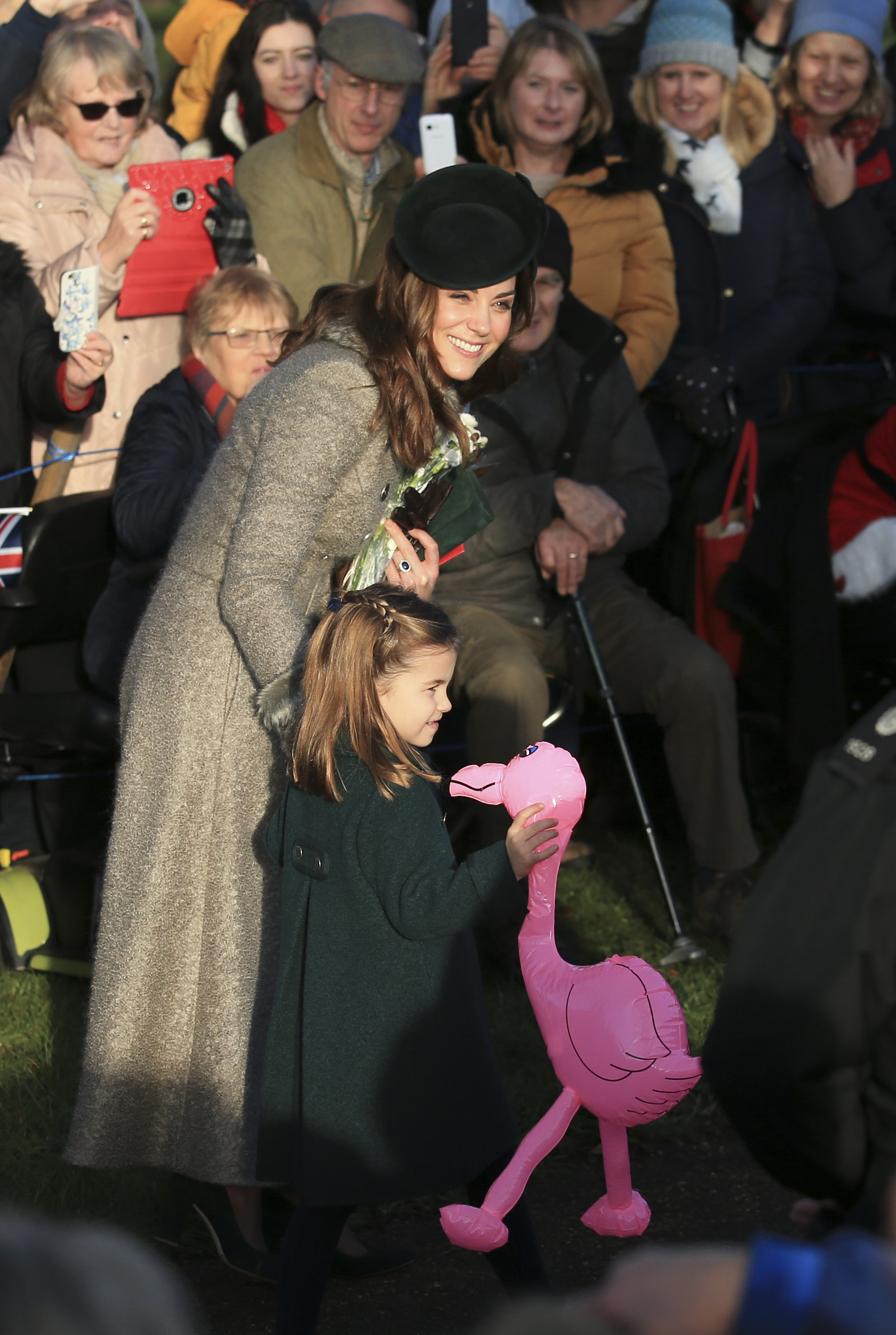 Britain's Catherine, Duchess of Cambridge speaks with her daughter Princess Charlotte as she holds a pink flamingo while greeting the public outside the St Mary Magdalene Church in Sandringham in Norfolk, England, on Wednesday.