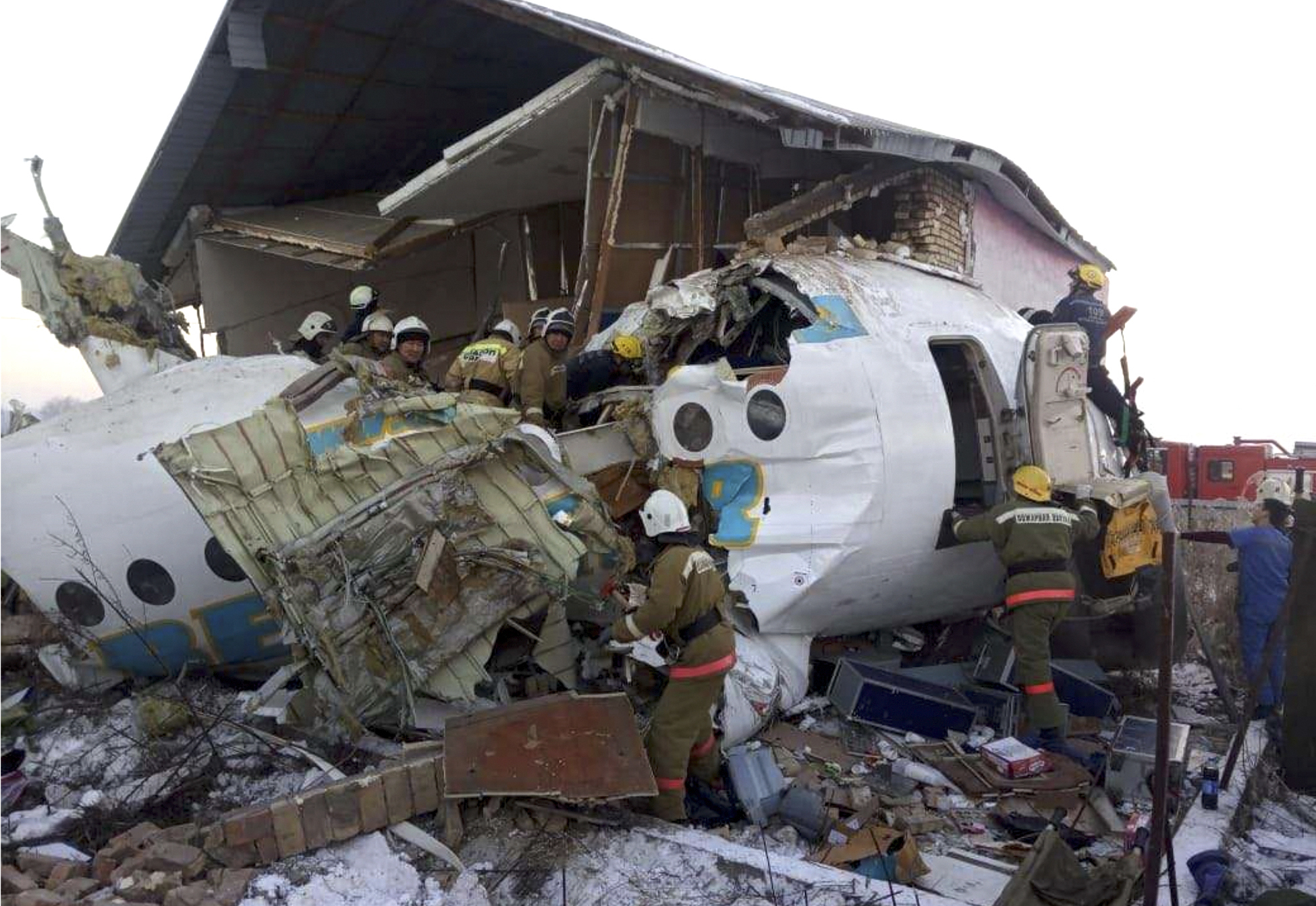 Police and rescuers work on the side of a plane crash