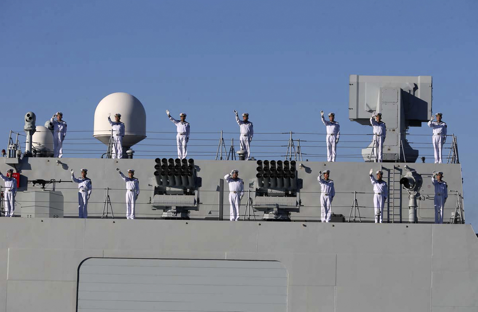 Chinese navy members wave while approaching to the Iran's southeastern port city of Chahbahar, in the Gulf of Oman.