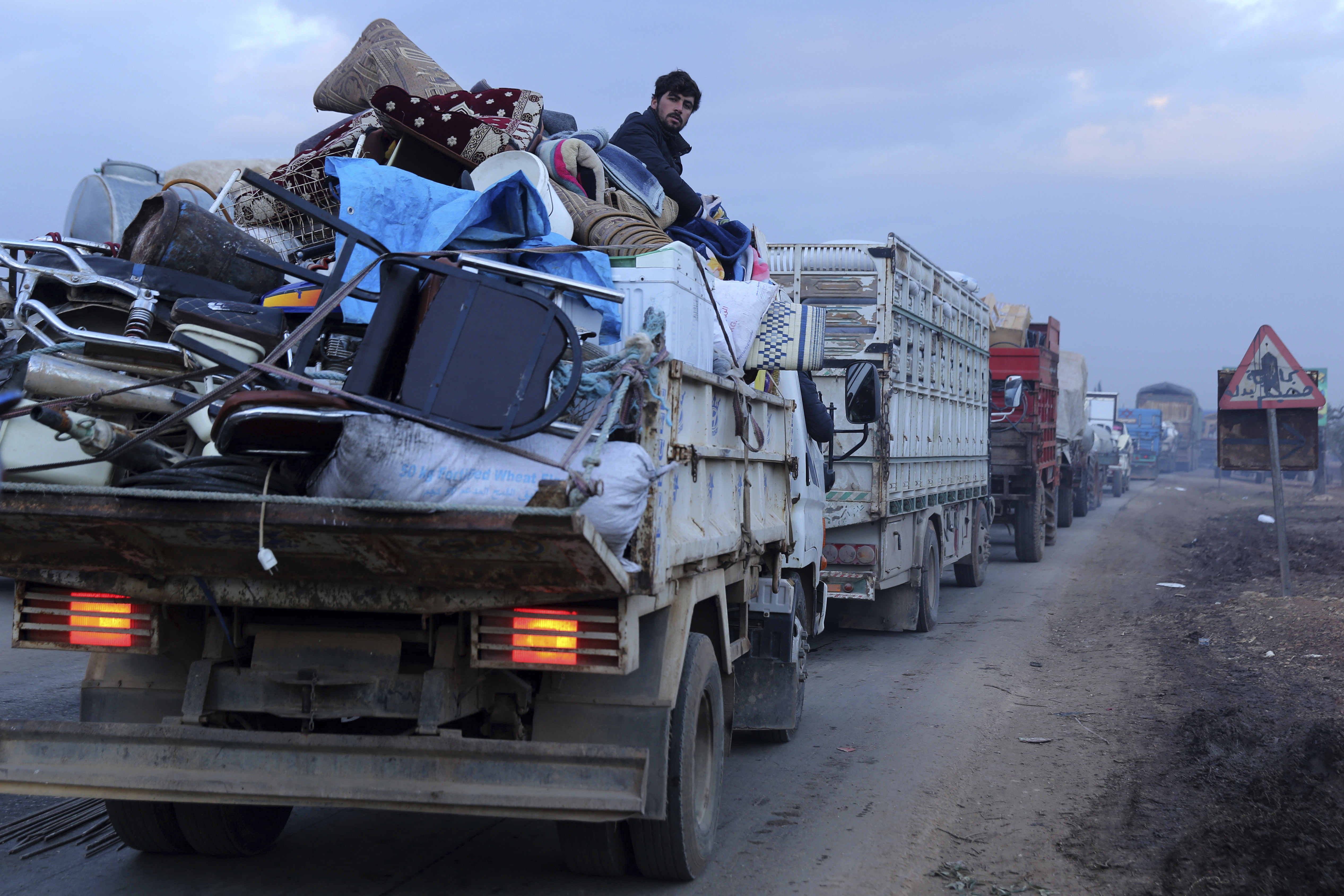 A man rides in a truck as civilians flee a Syrian military offensive in Idlib province on the main road near Hazano in Syria, on Tuesday.