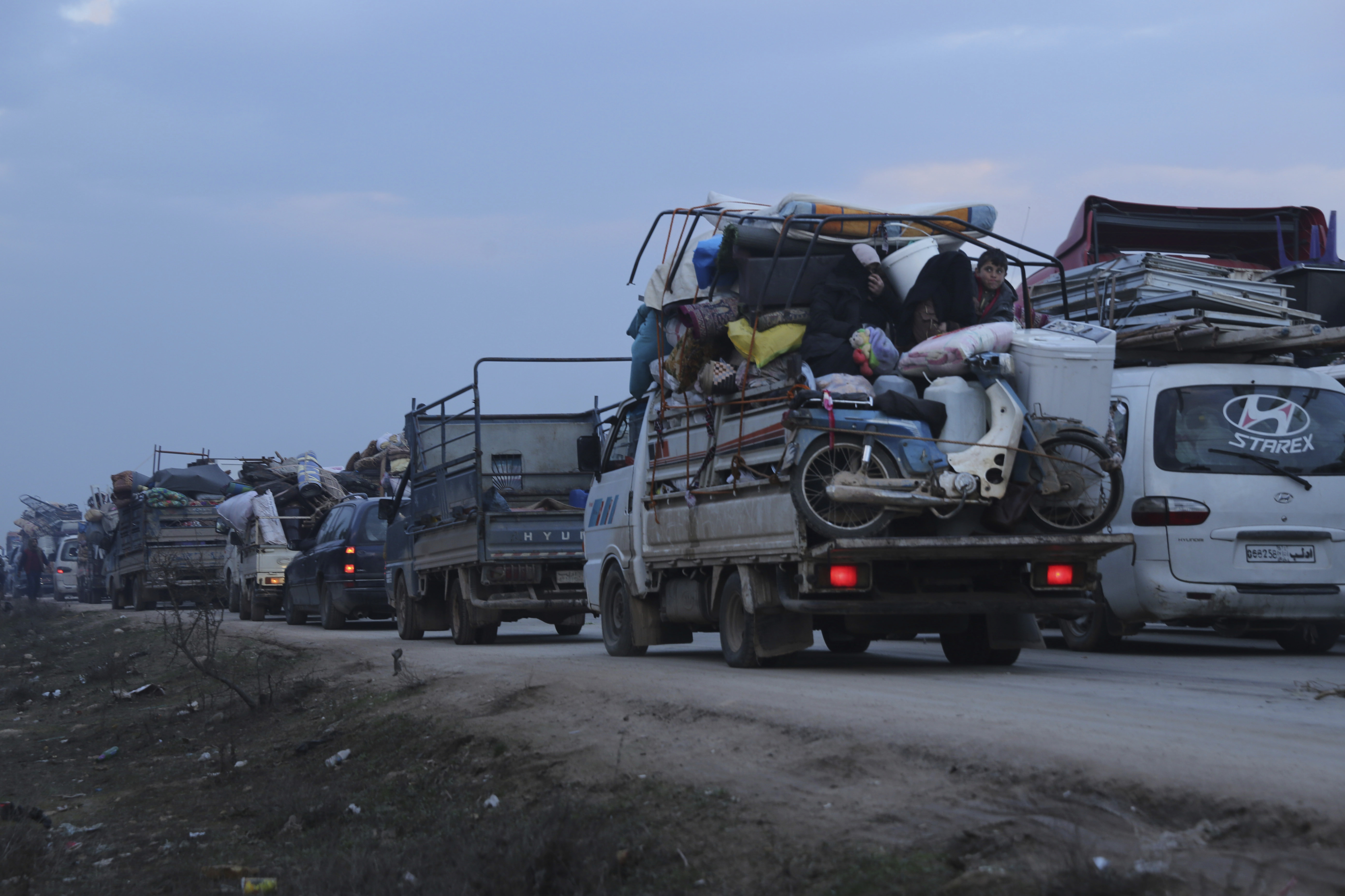 Truckloads of civilians flee a Syrian military offensive in Idlib province on the main road near Hazano in Syria, on Tuesday.