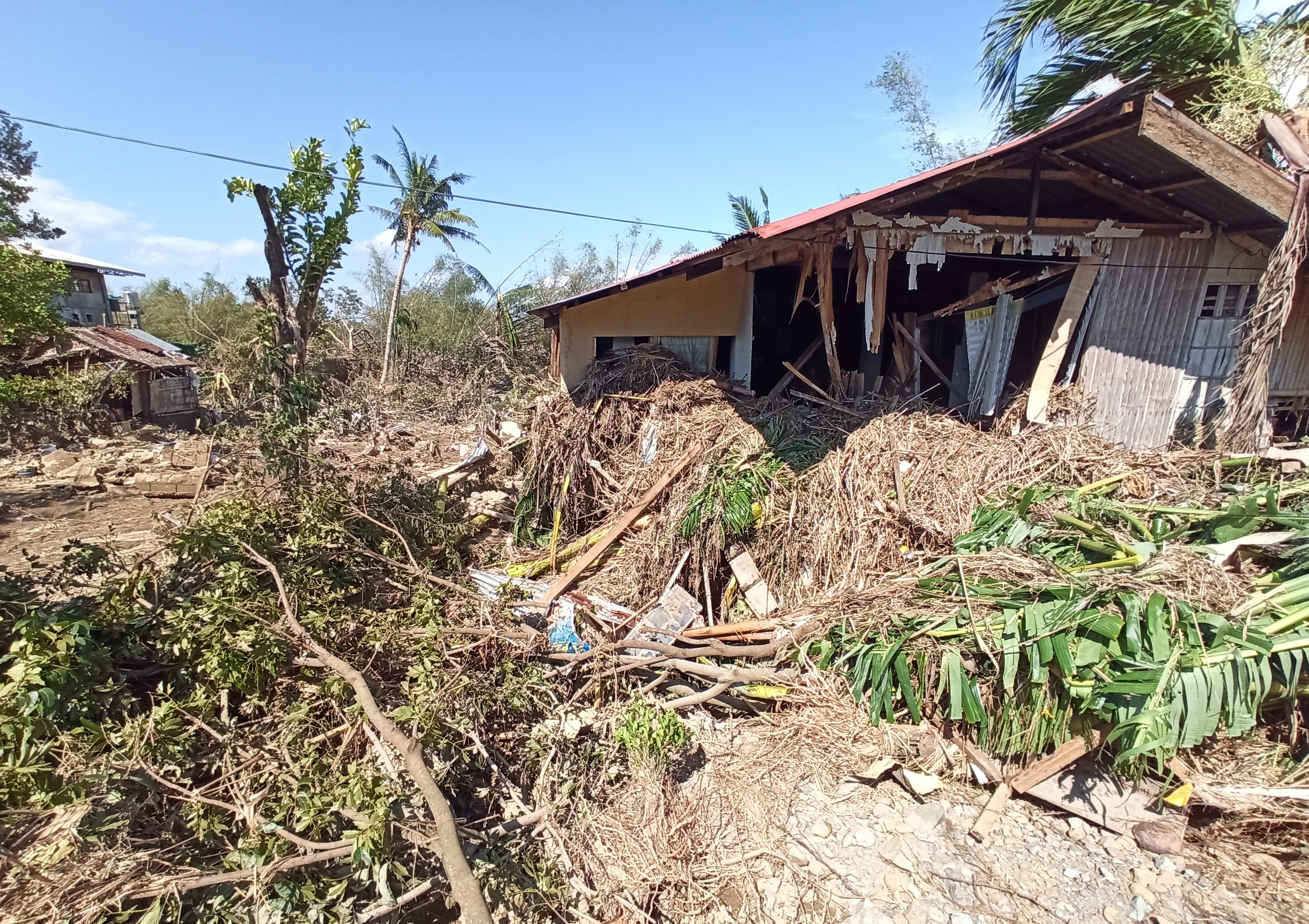 Debris from floods caused by Typhoon Phanfone surround a damaged house in Balasan Town, Iloilo province, central Philippines on Thursday.