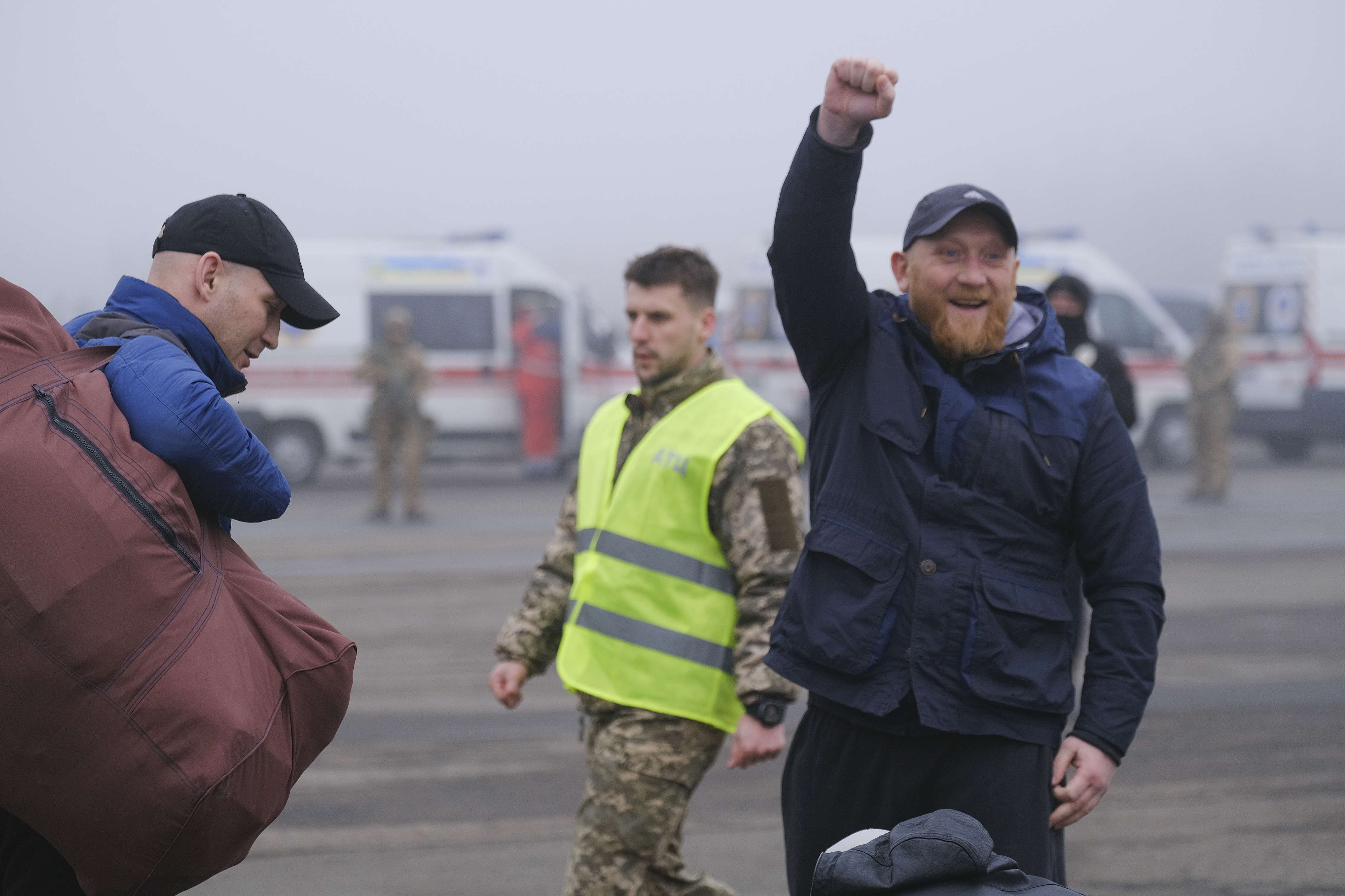 A pro-Russian prisoner makes a fist next to an Ukrainian police officer during a prisoner exchange between Ukrainian and pro-Russian rebels sides, near the Maiorske checkpoint, Donetsk area, Ukraine, on Sunday.