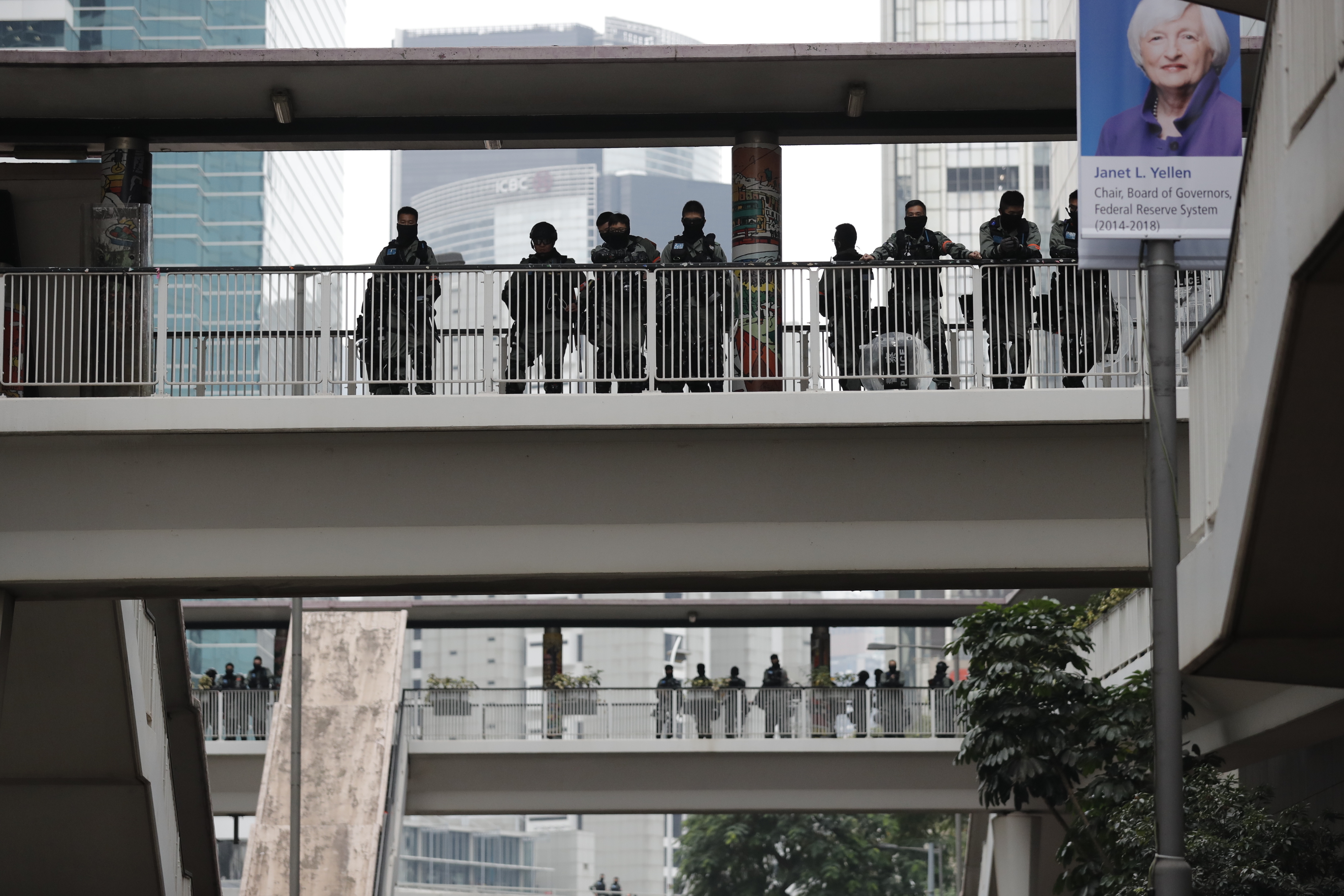 Riot police watch from an overhead bridge as Hong Kong people participate in their annual pro-democracy march to insist their five demands be matched by the government in Hong Kong, on Wednesday.