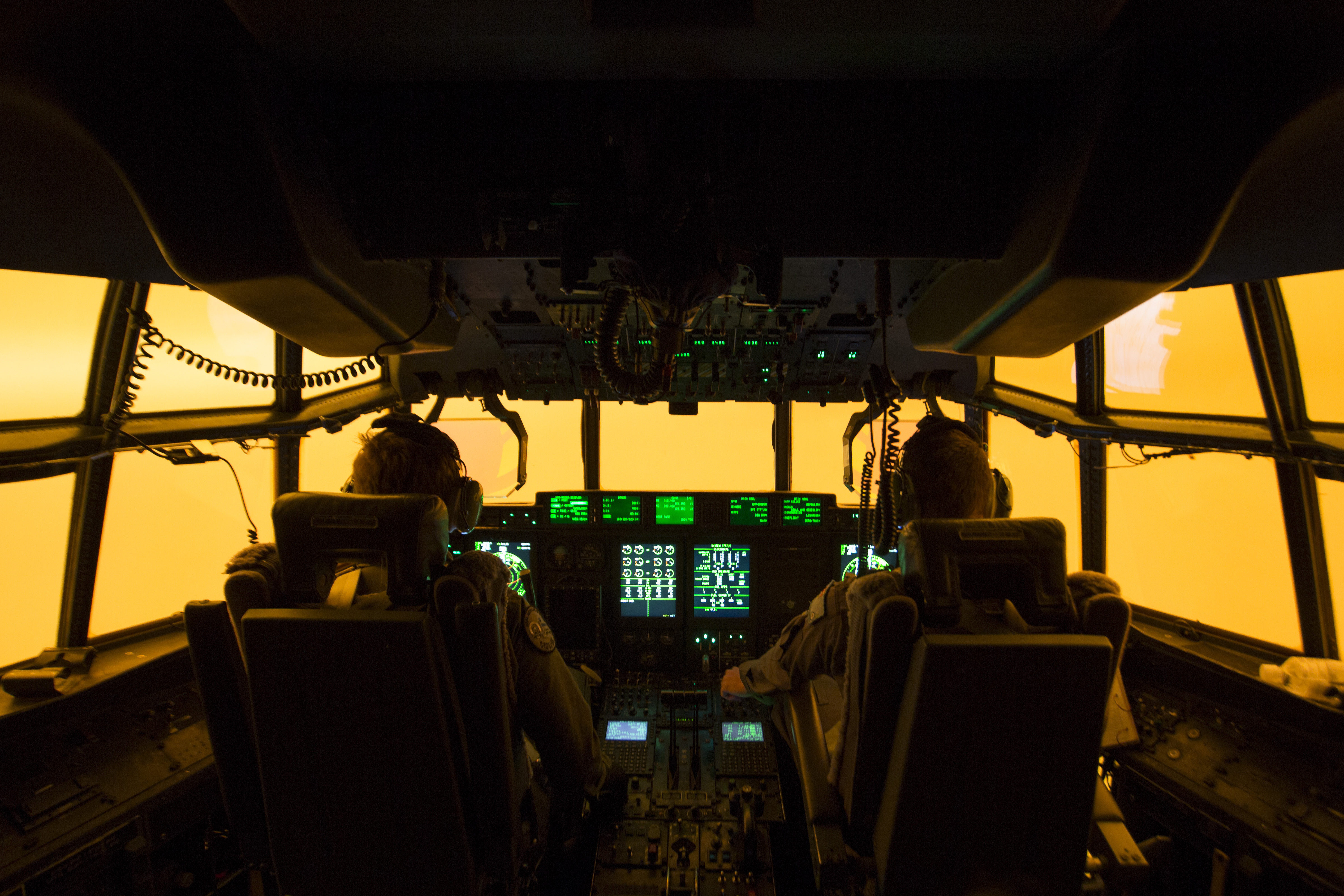 The flight deck of a C-130J Hercules aircraft has a warm glow from wildfires, as they prepare to land at Merimbula airfield to deploy fire and rescue crews on Friday.