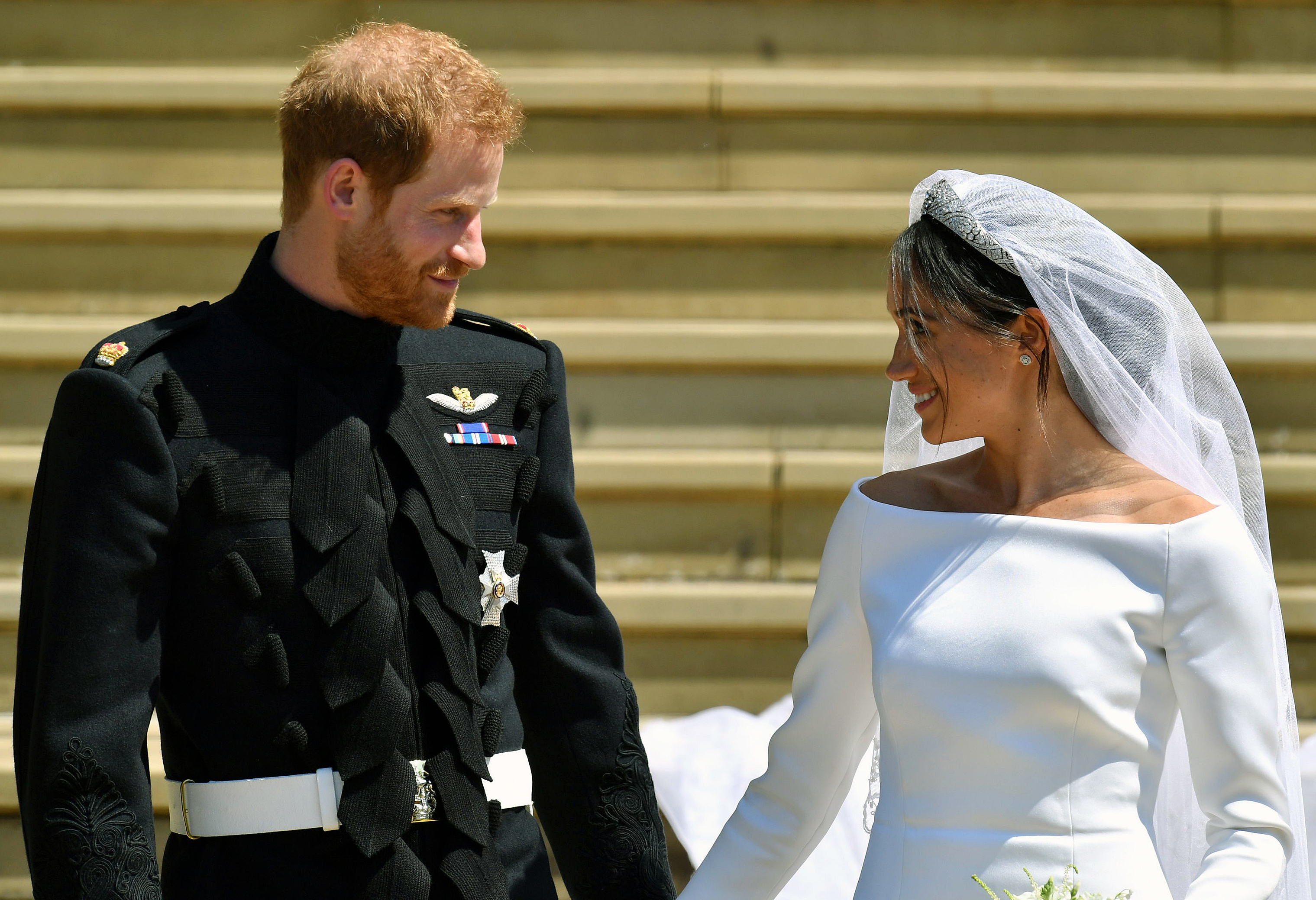 In this Saturday, May 19, 2018 file photo, Britain's Prince Harry and Meghan Markle walk down the steps after their wedding at St. George's Chapel in Windsor Castle in Windsor, England.