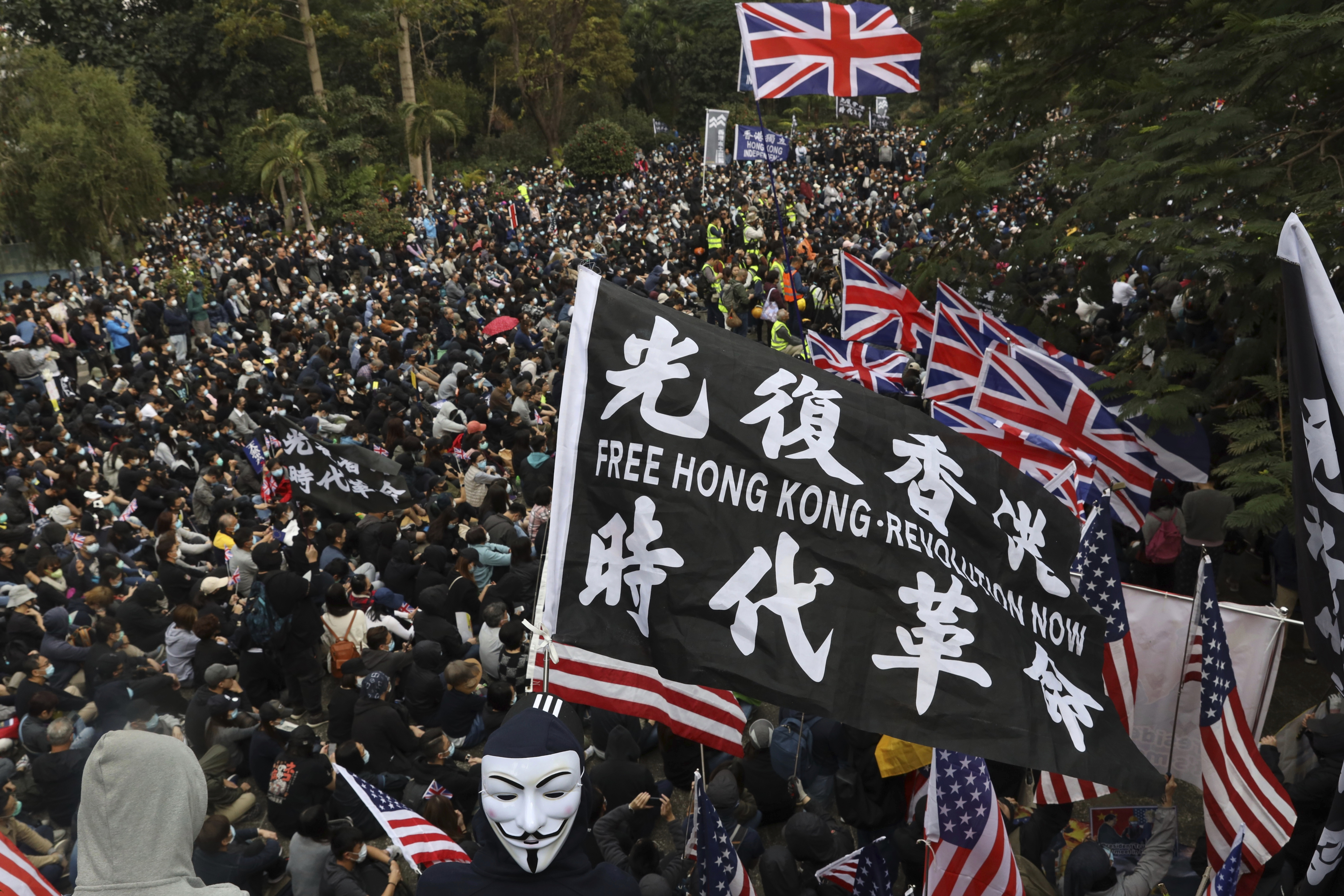 Participants wave British and U.S. flags during a rally demanding electoral democracy and call for boycott of the Chinese Communist Party and all businesses seen to support it in Hong Kong, on Sunday.