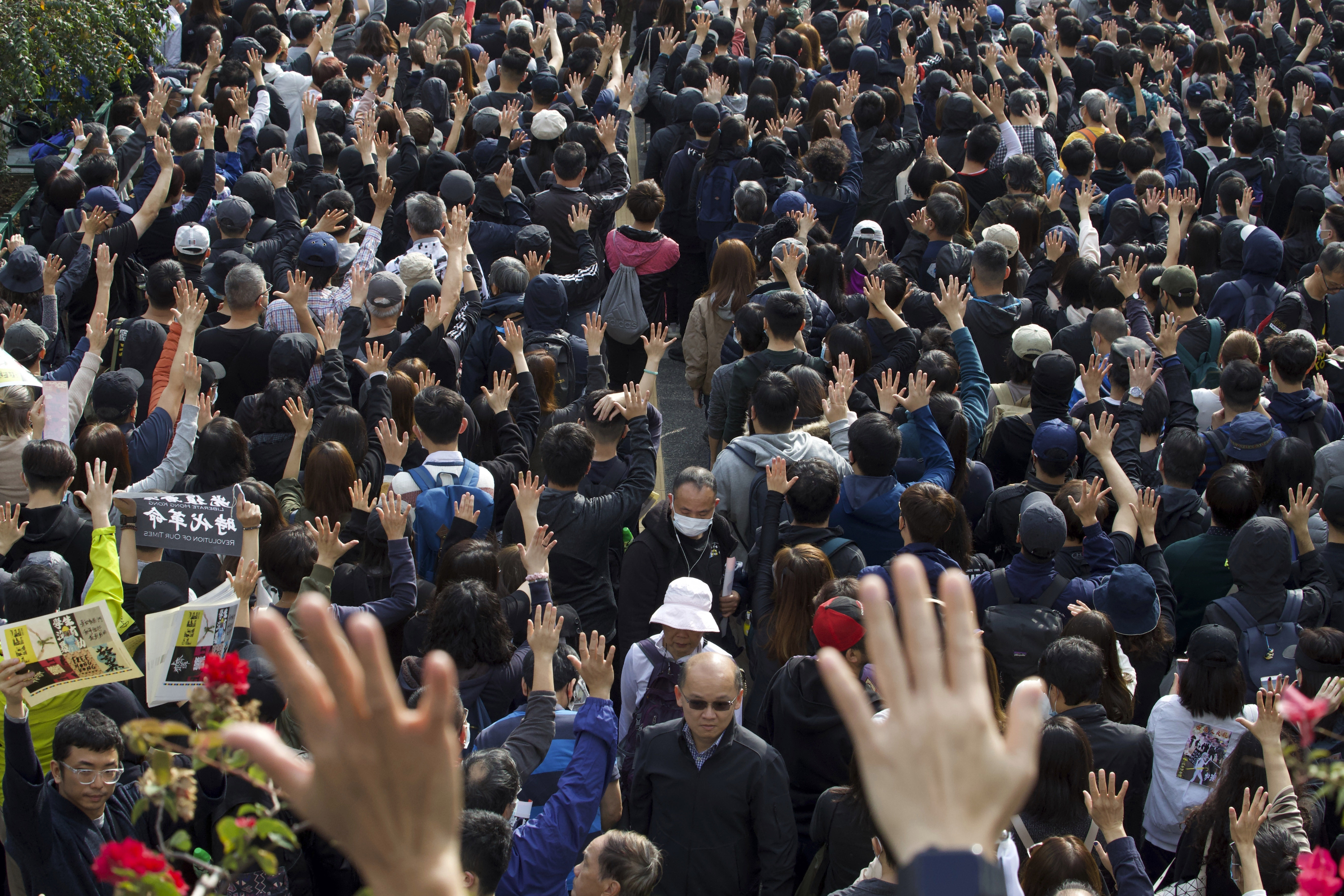 Participants raise their hands to show five demands during a rally demanding electoral democracy and call for boycott of the Chinese Communist Party and all businesses seen to support it in Hong Kong, on Sunday.