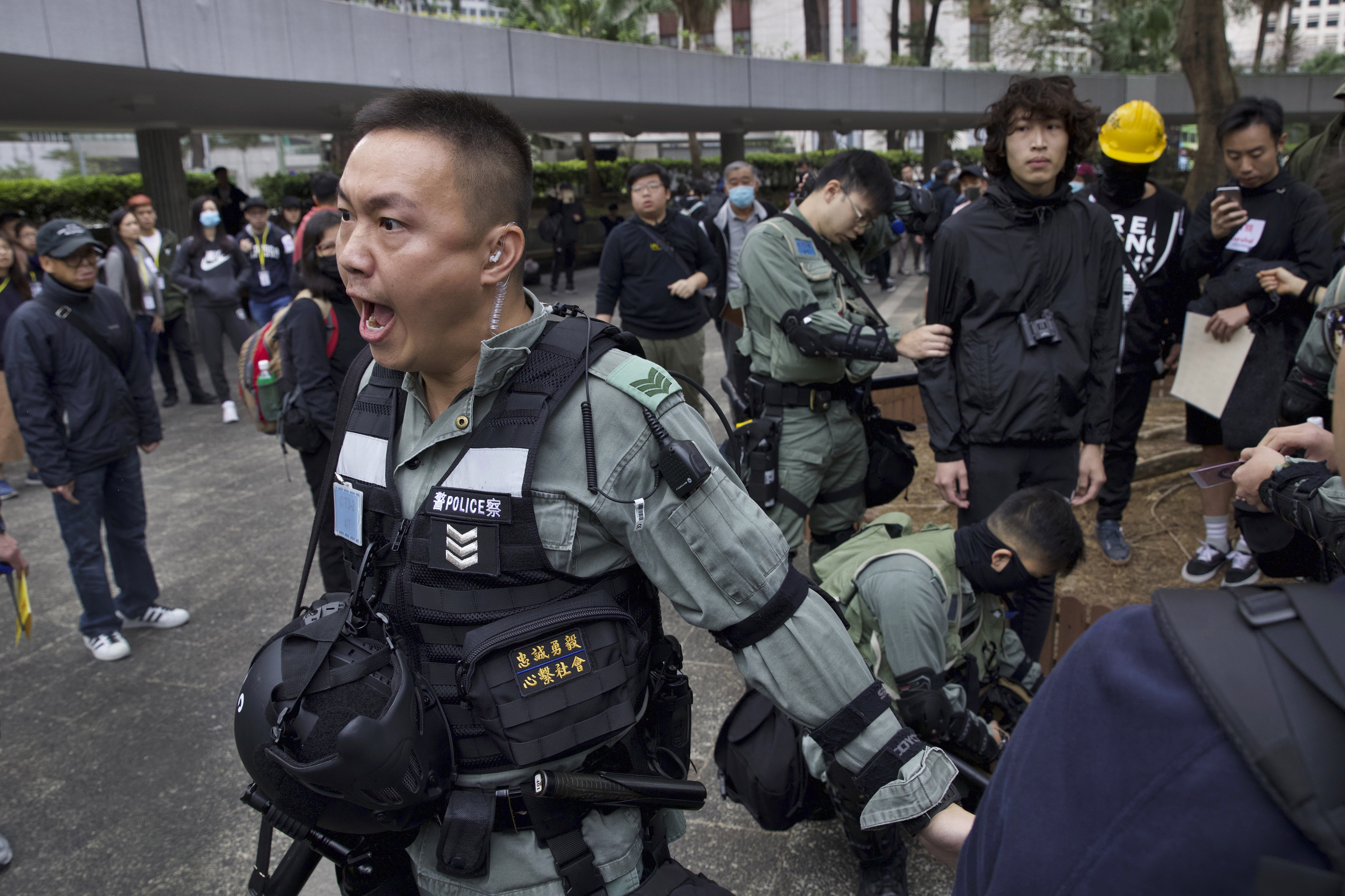 Riot police perform body search on a man ahead of a rally demanding electoral democracy and call for boycott of the Chinese Communist Party and all businesses seen to support it in Hong Kong, on Sunday.