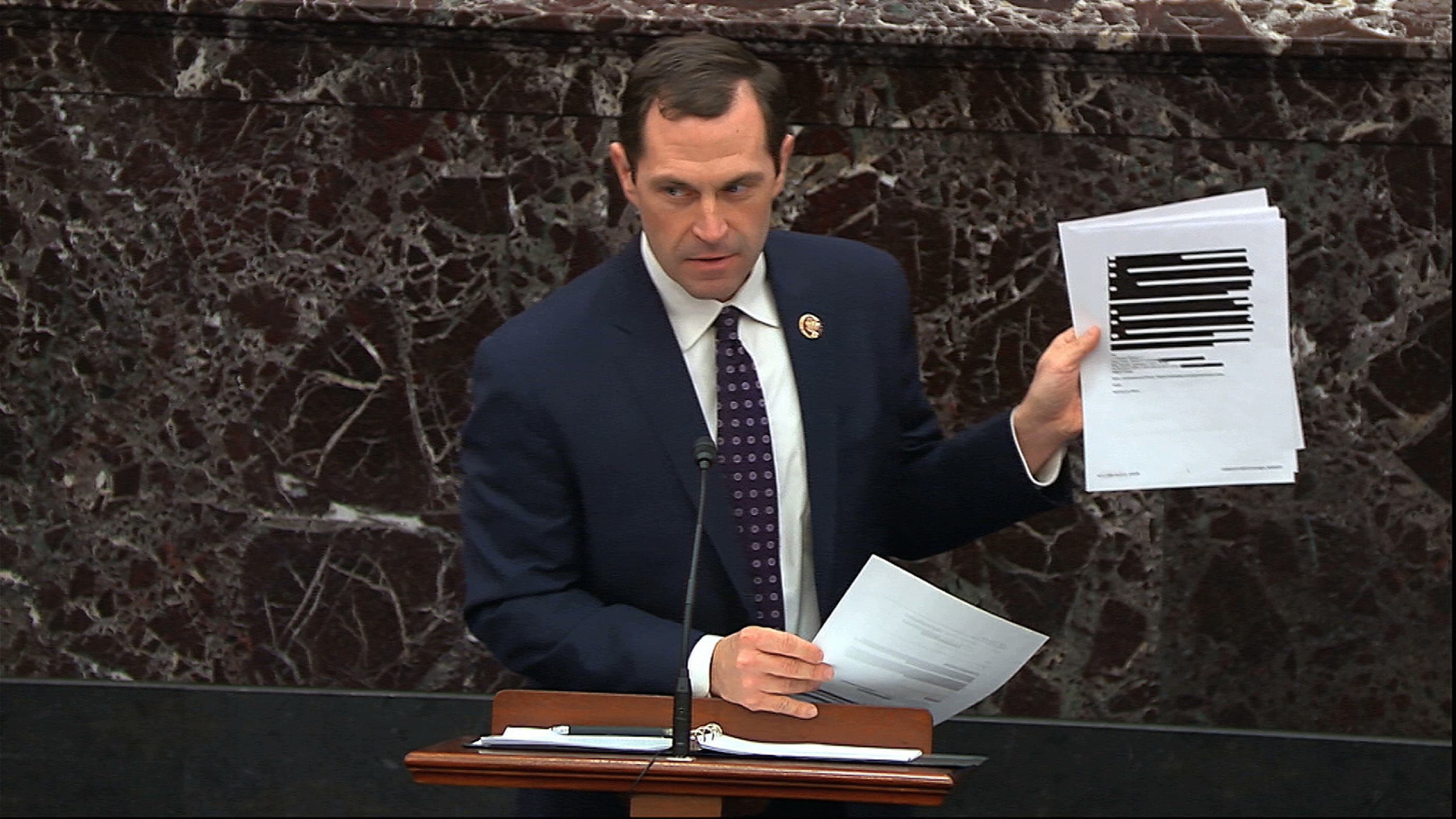 House impeachment manager Rep. Jason Crow, D-Colo., holds up documents released by the Office of Management and Budget (OMB) under a Freedom of Information Act request as he speaks during the impeachment trial against President Donald Trump in the Senate at the U.S. Capitol in Washington, on Wednesday.