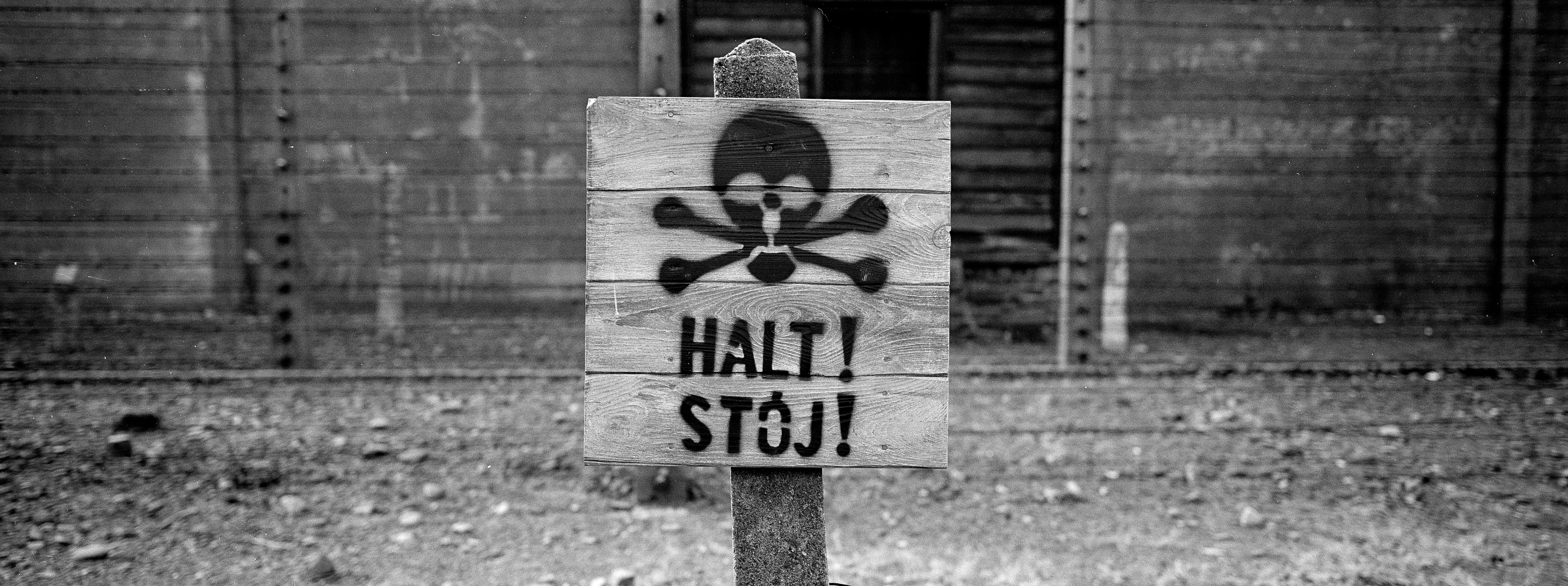 A wooden sign with the word STOP stands in front of what was an electric barbed wire fence inside the former Nazi death camp of Auschwitz I, in Oswiecim, Poland. (File photo)