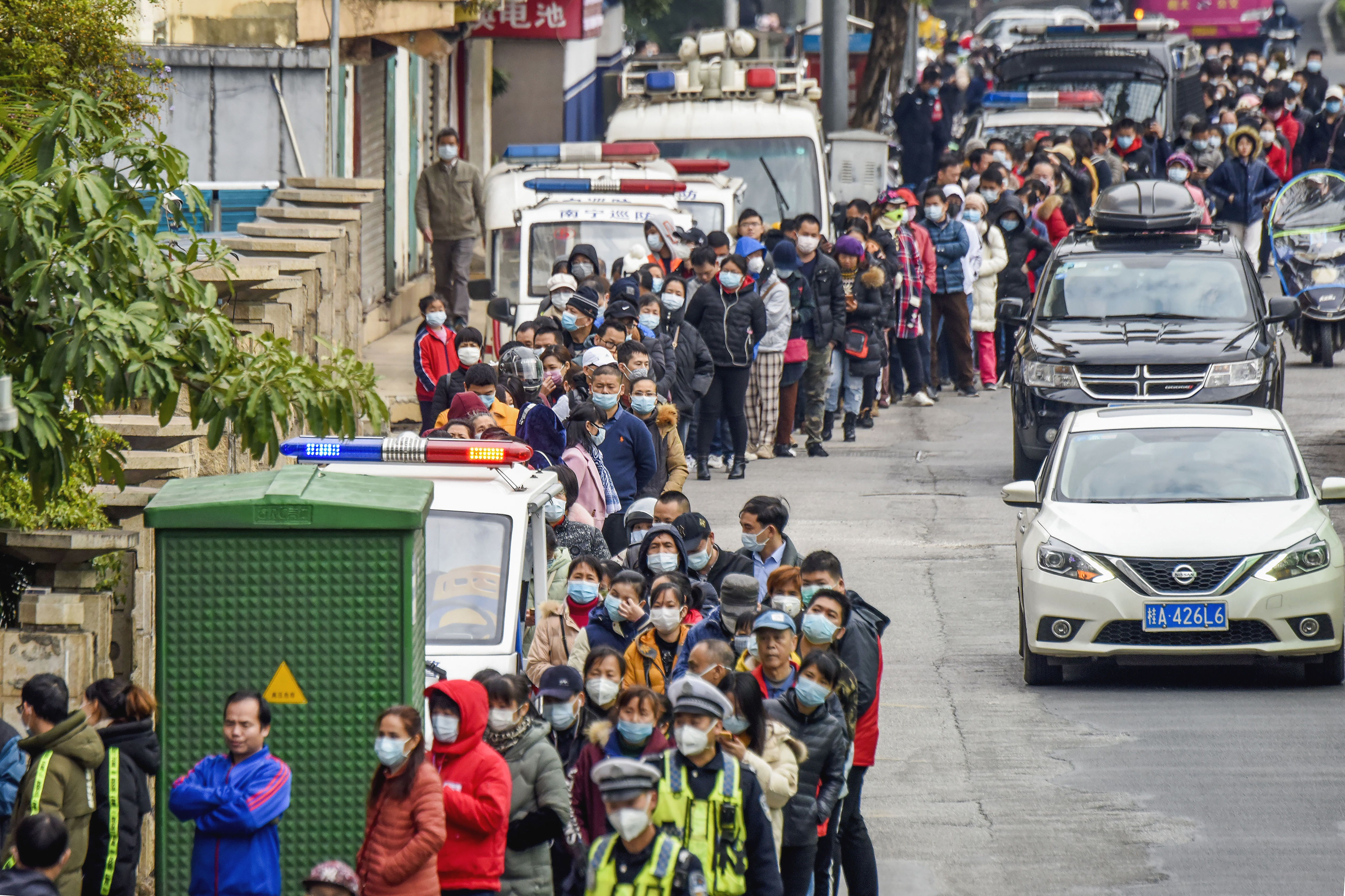 People line up to buy face masks from a medical supply company in Nanning in southern China's Guangxi Zhuang Autonomous Region