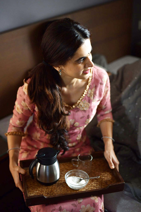 taapsee is seen as a house-maker holding a tea tray with a flask, a cup and a bowl of sugar in tappad movie