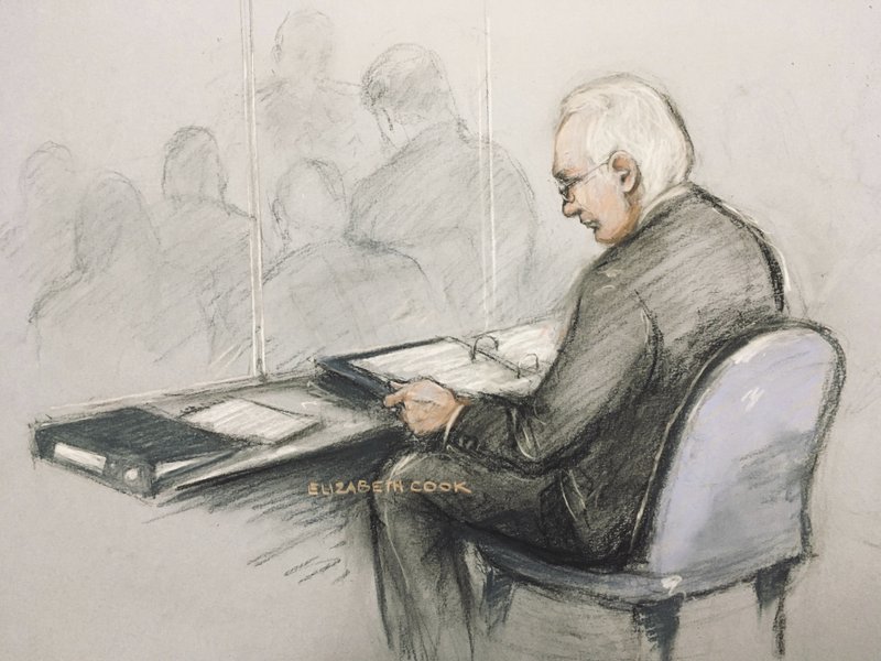 This is a court artist sketch of Wikileaks founder Julian Assange in the dock reading his papers as he appears at Belmarsh Magistrates' Court for his extradition hearing, in London
