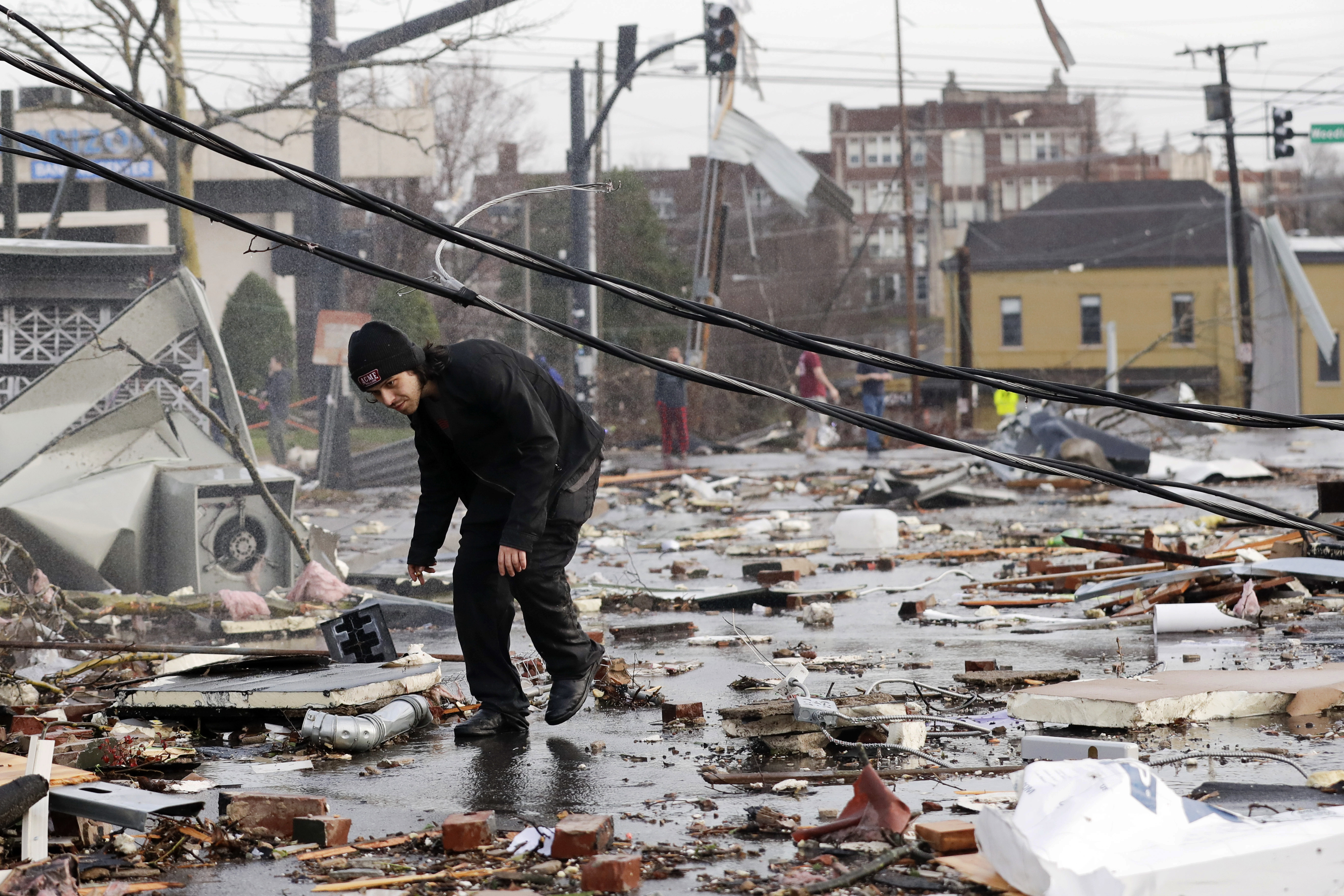 A man walks through storm debris following a deadly tornado Tuesday in Nashville, Tenn.