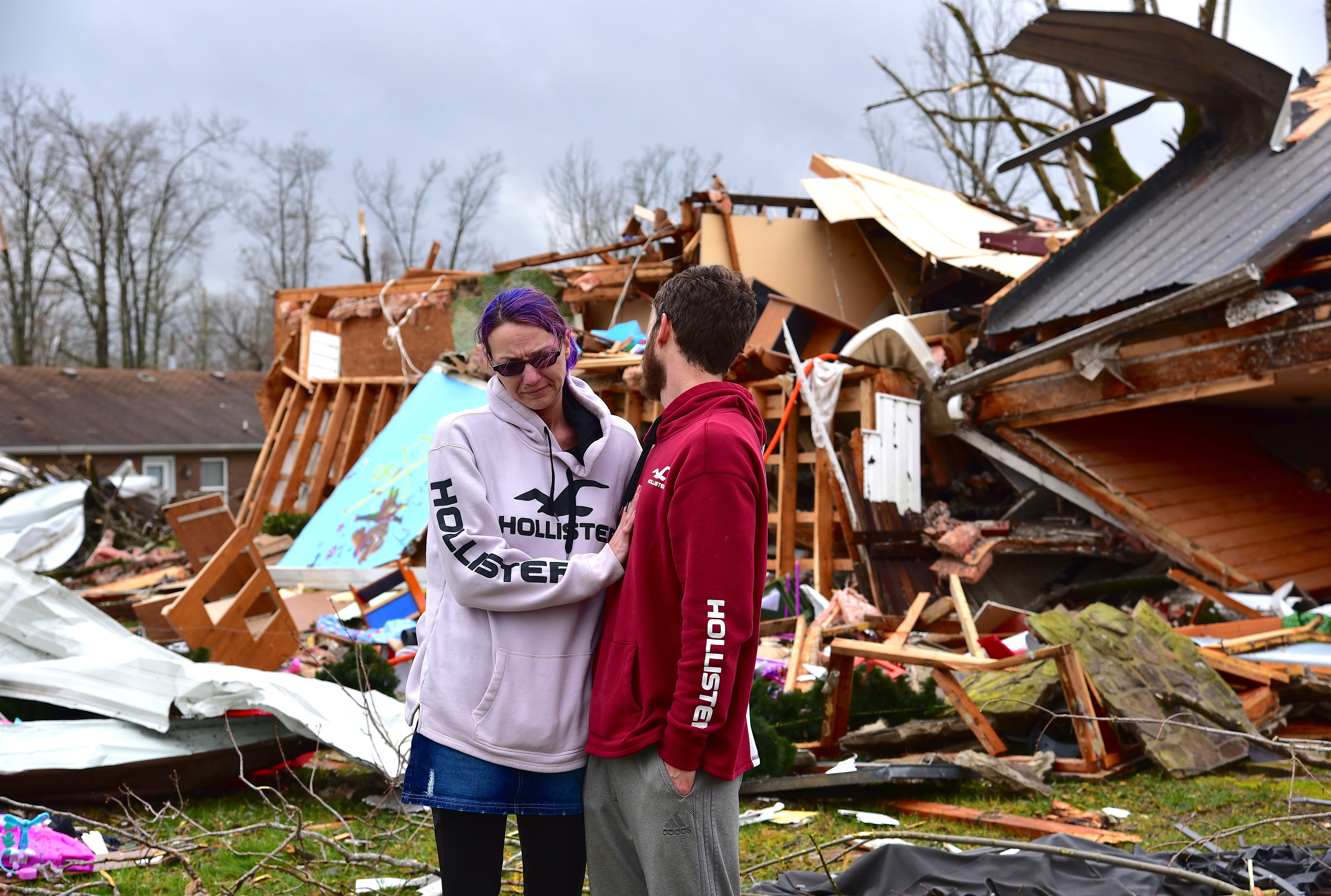 Deanna and Tony Speck, of Cookeville, Tenn., console one another on the front lawn of what's left of Deanna's parent's house off Locust Grove Road on the western edge of Cookeville, Tenn., Tuesday.