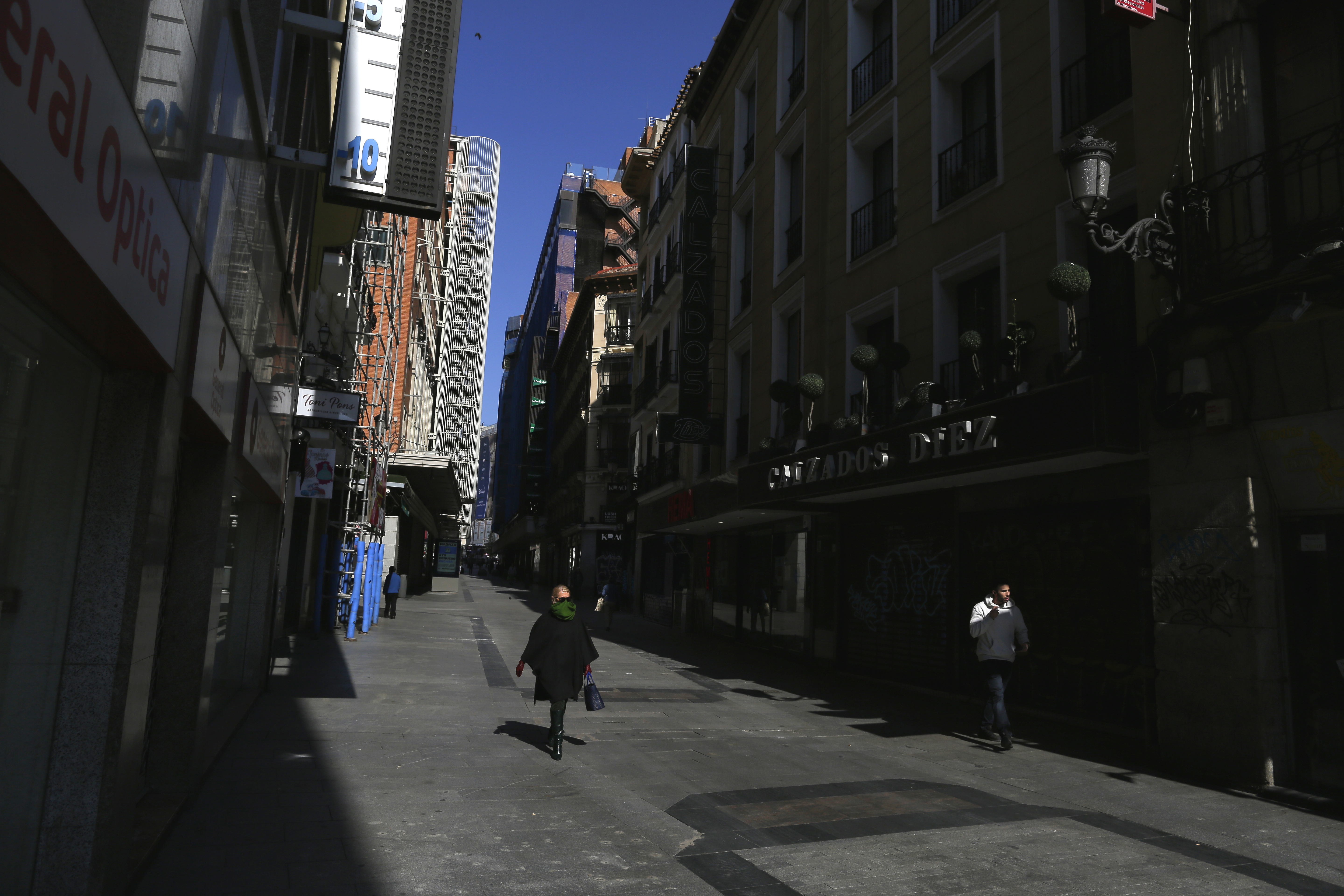 People walk among closed shops in downtown Madrid, Spain, on Saturday.