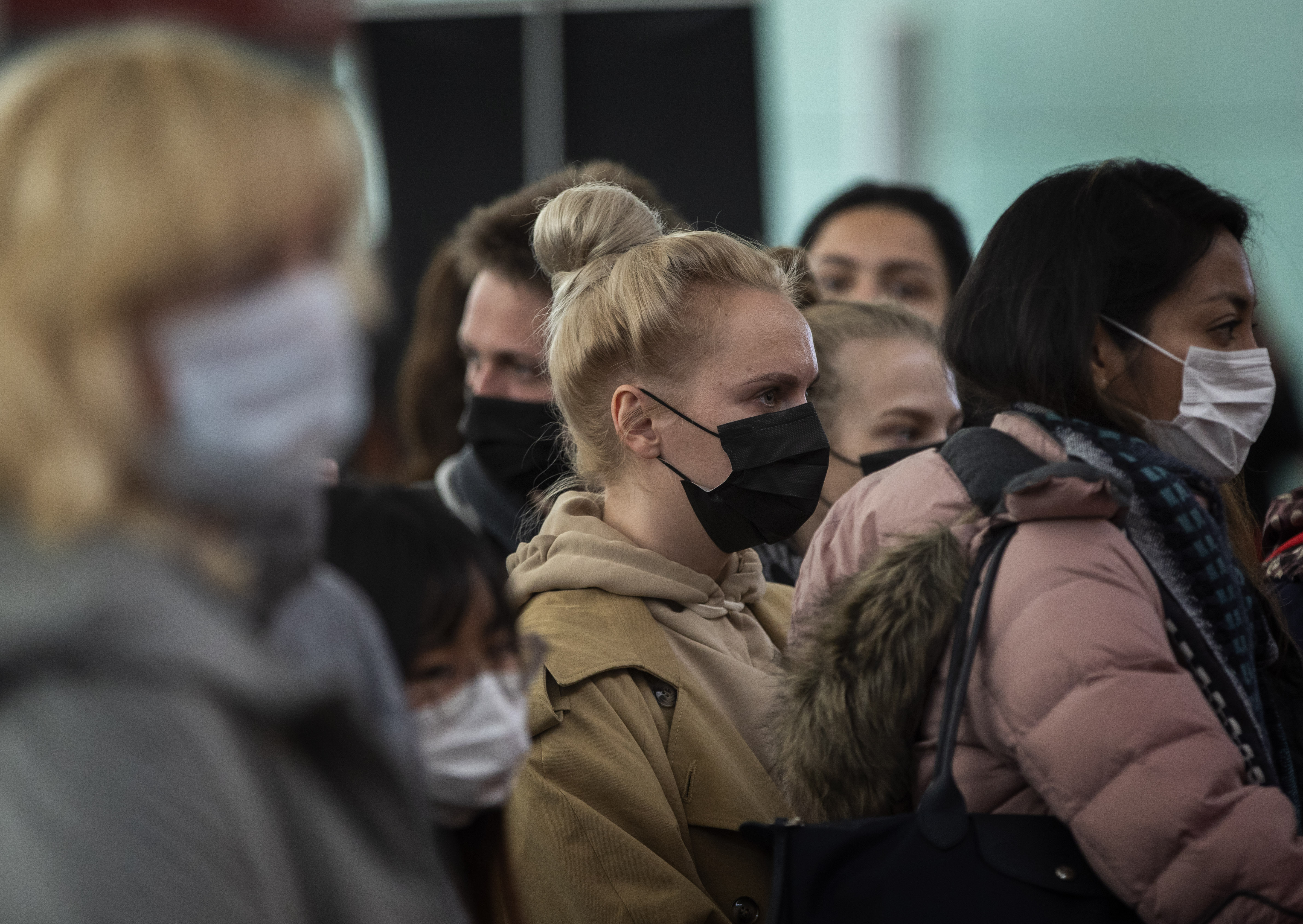 Passengers wearing masks line up as they wait to check in at Barcelona airport, Spain, on Saturday.