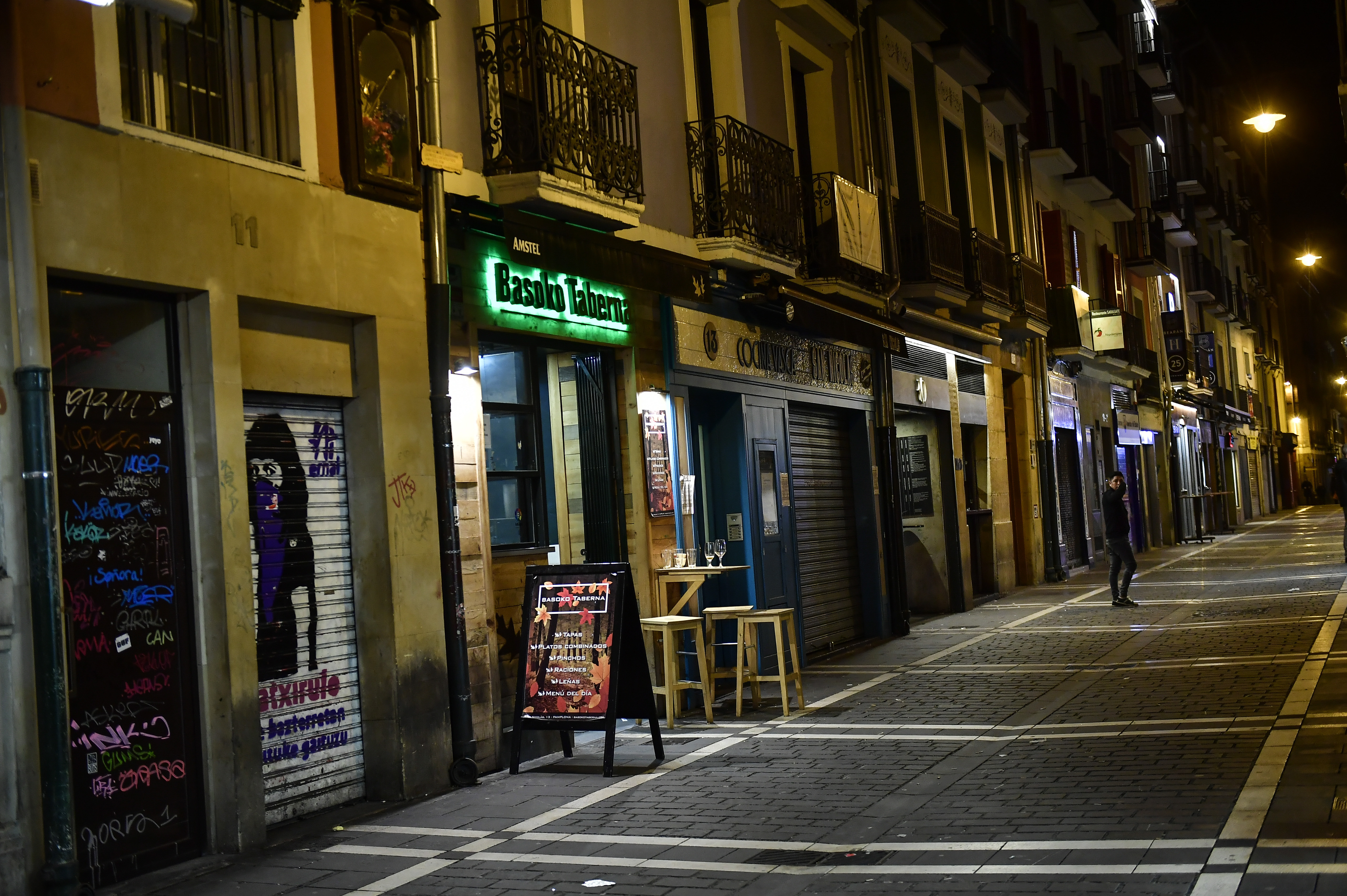 A person walks along the unusually deserted Saint Nicolas street, to prevent the spread of coronavirus, in Pamplona, northern Spain, on Friday.